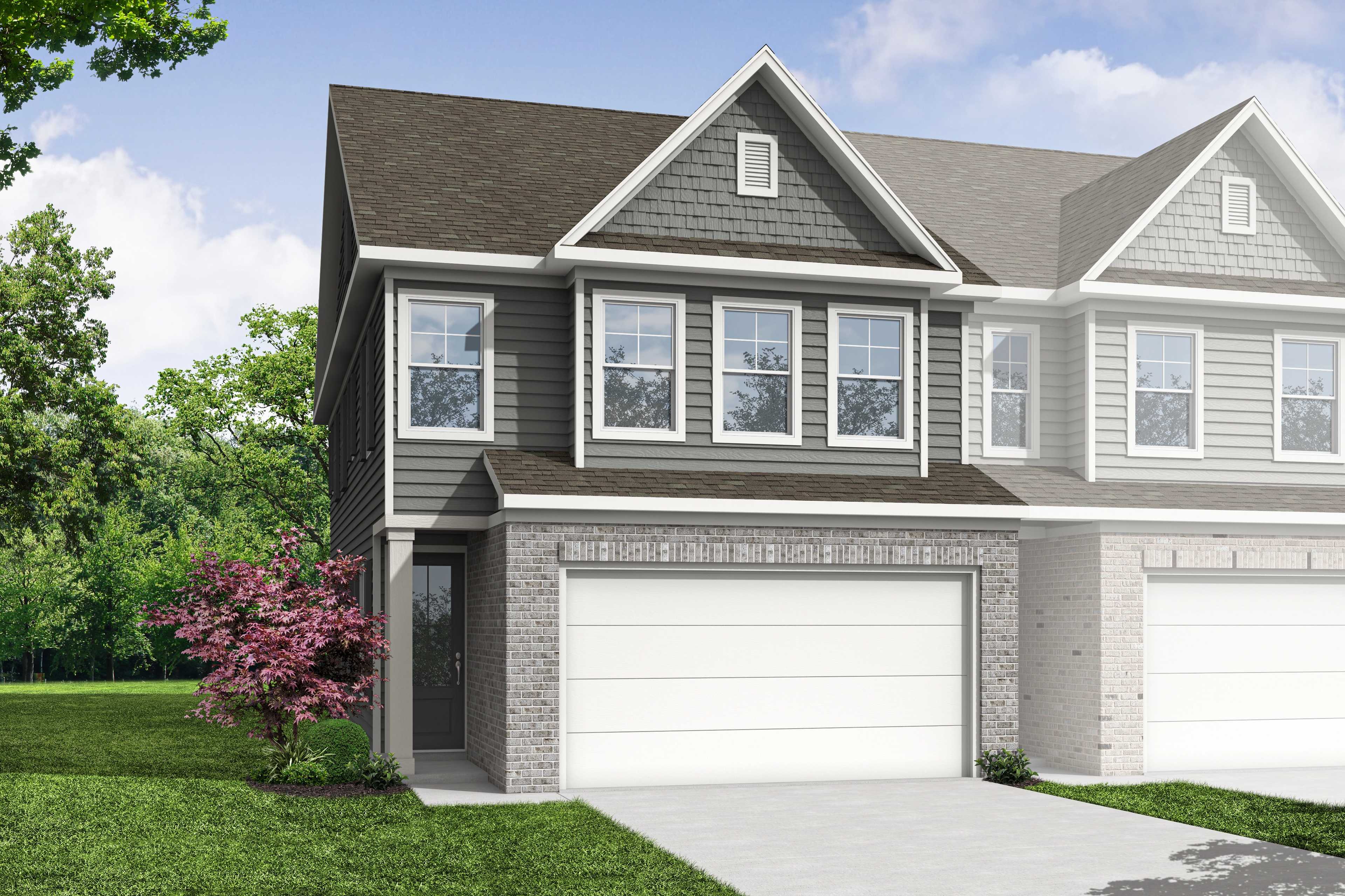 The Wake B multi-family duplex in Cumming GA: 2-story units with gray siding, brick accents, 2-car garages, and tree-lined front yard