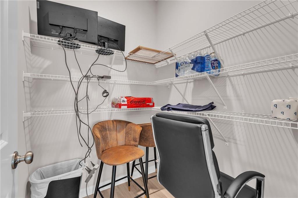 Functional home office closet with dual monitors, wire shelving, ergonomic chairs in Davidson Homes The Bartlett, Phenix City, Alabama