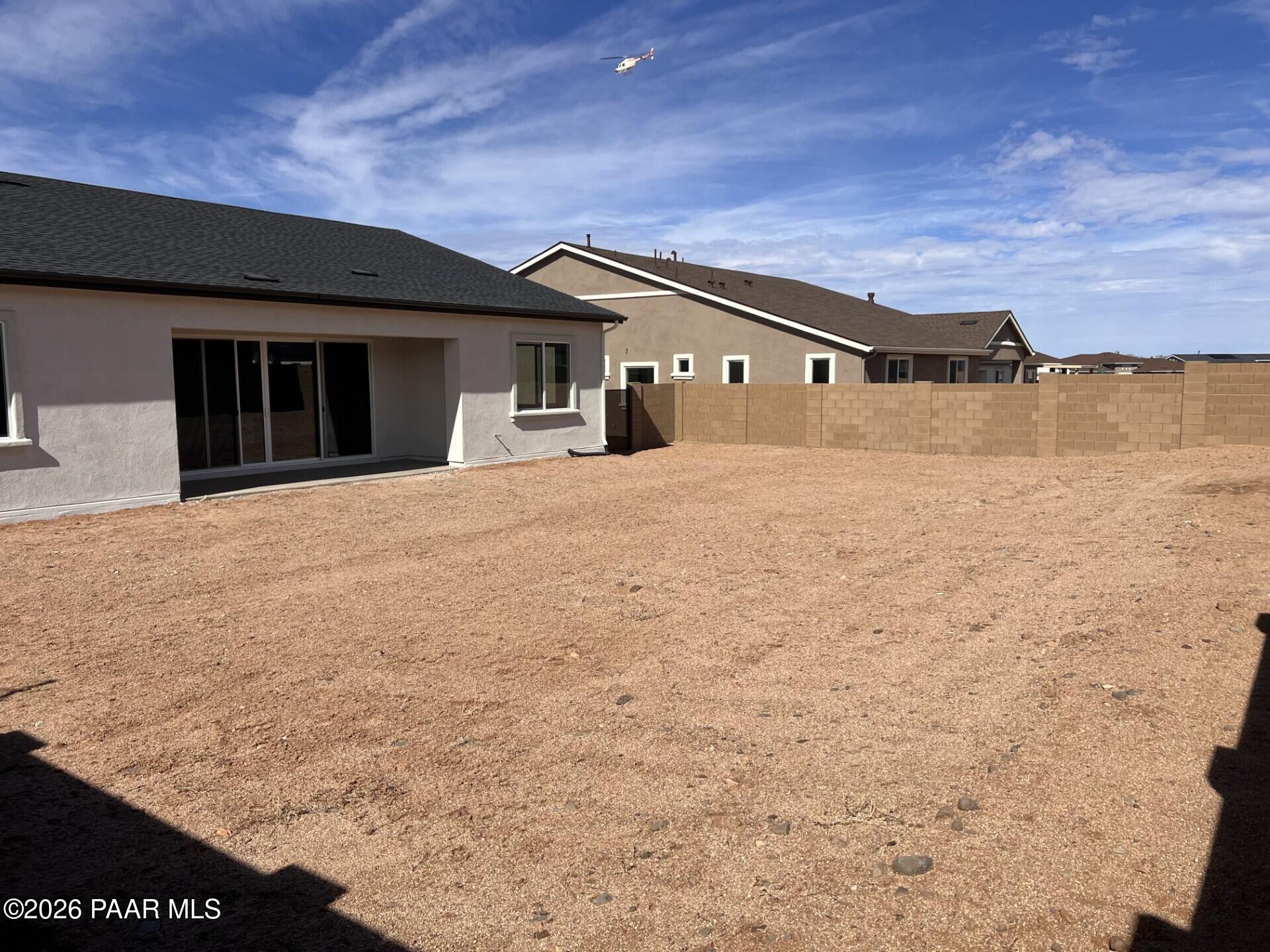 Spacious gravel backyard with covered patio and sliding glass doors in Davidson Homes The Summit A, Westwood, Prescott, Arizona