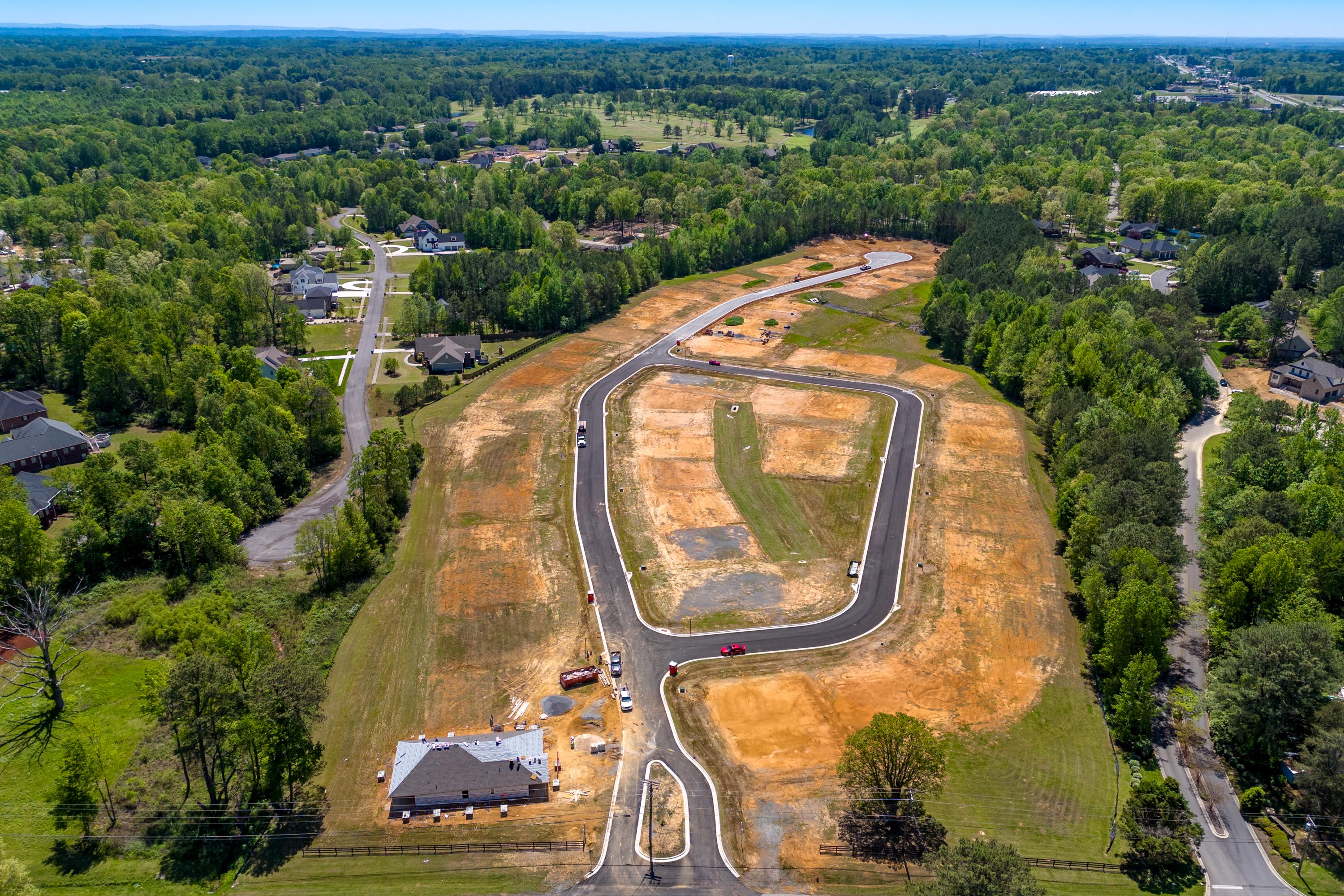 Aerial view of The Highlands neighborhood in Arab, Alabama with new roads, construction sites and homes amid lush forests