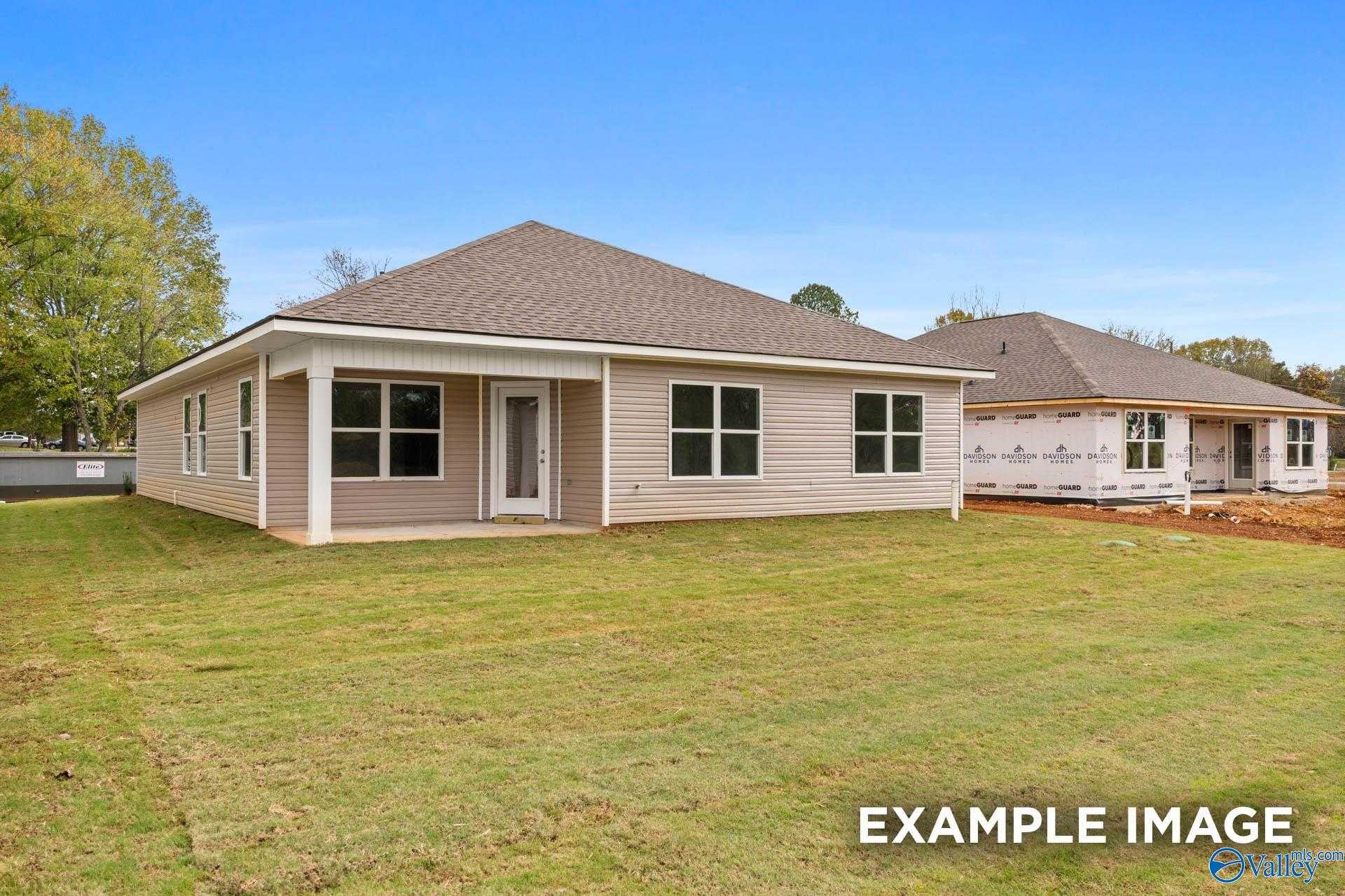 Modern beige single-story home with gabled roof, covered porch, and large windows on green lawn in Chapel Hill, Athens, Alabama