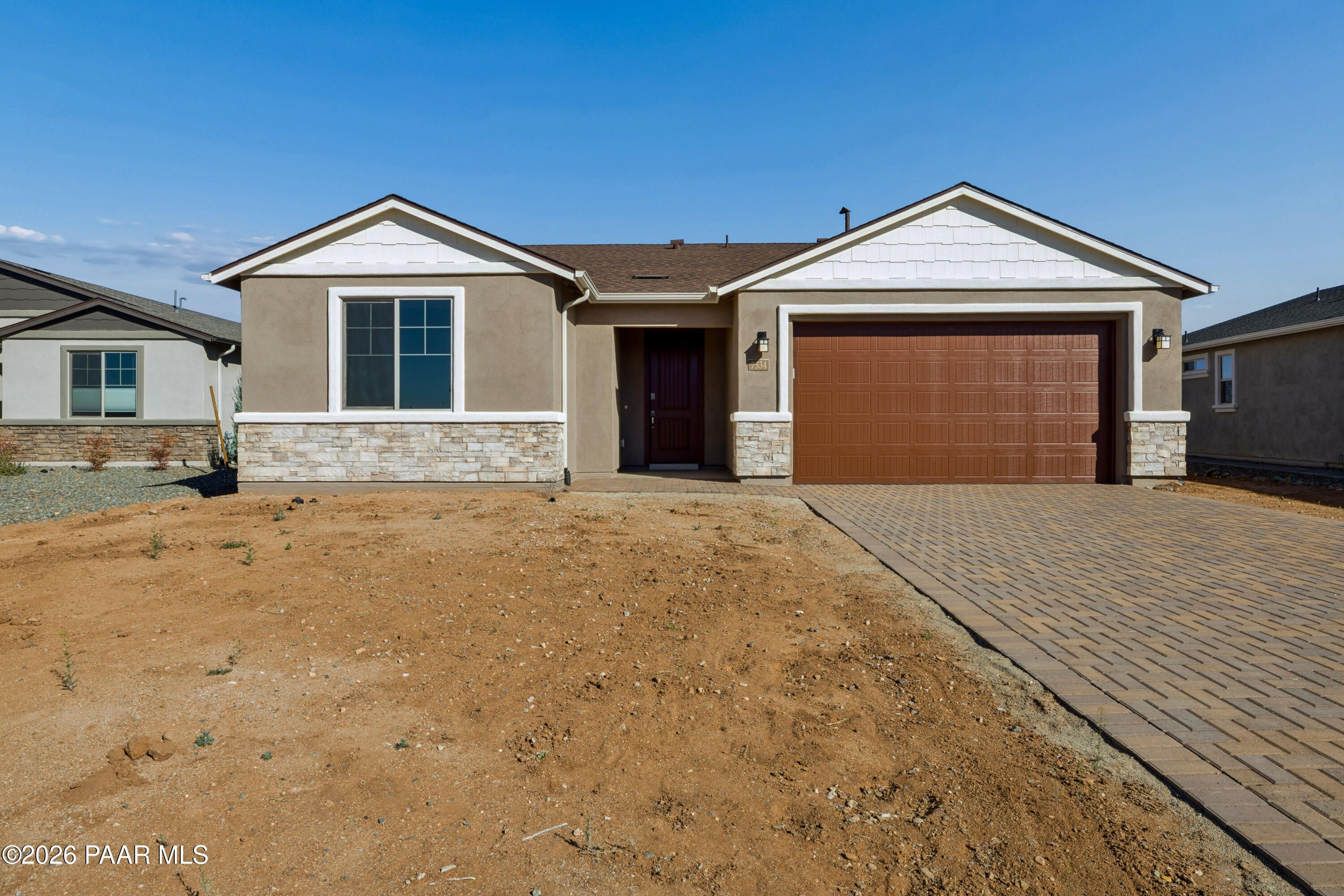 Modern 1-story Davidson Homes Harmony A exterior with 3-car garage and paver driveway in Prescott Valley, Arizona