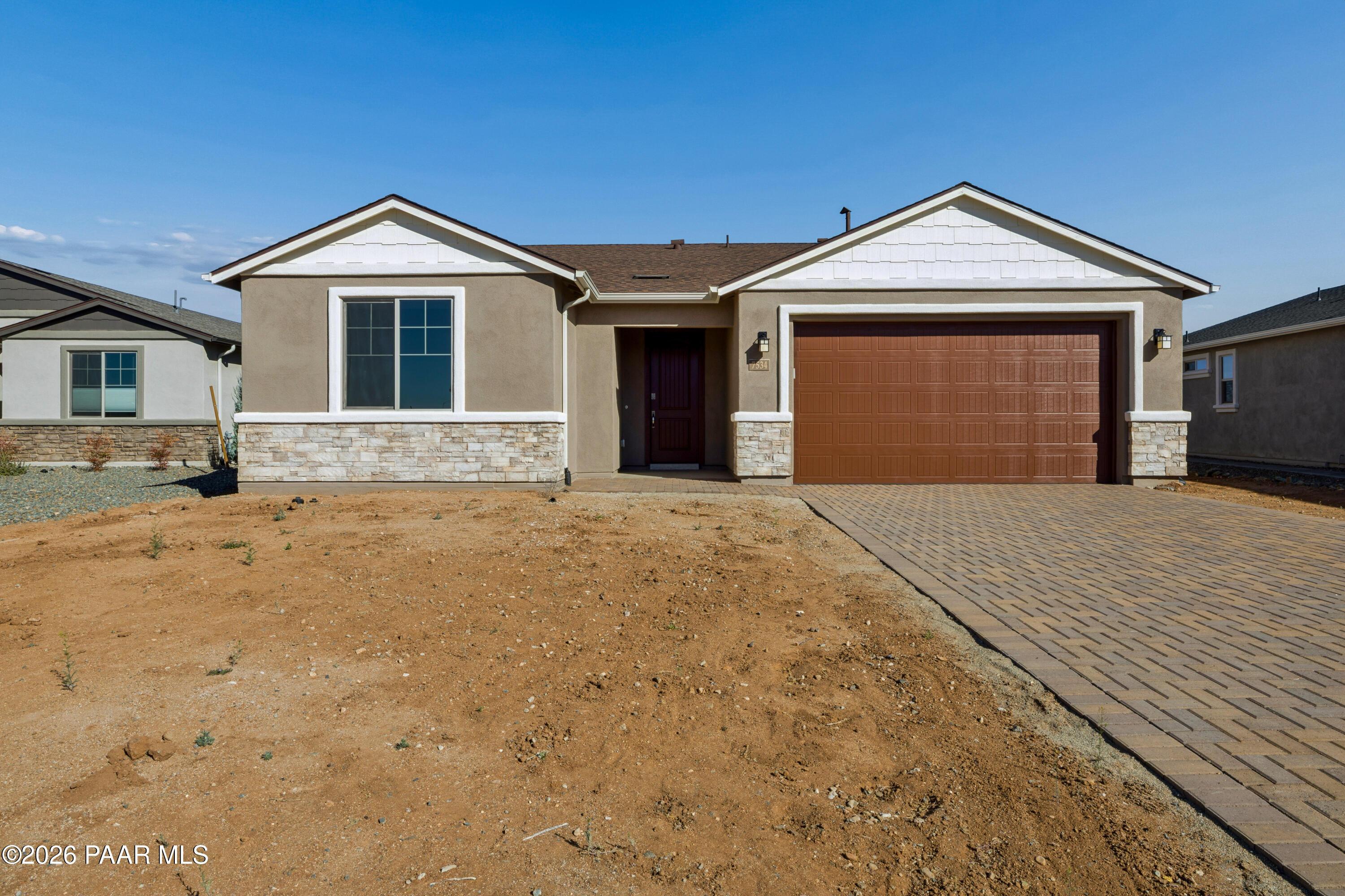 Modern 1-story Davidson Homes Harmony A exterior with 3-car garage and paver driveway in Prescott Valley, Arizona