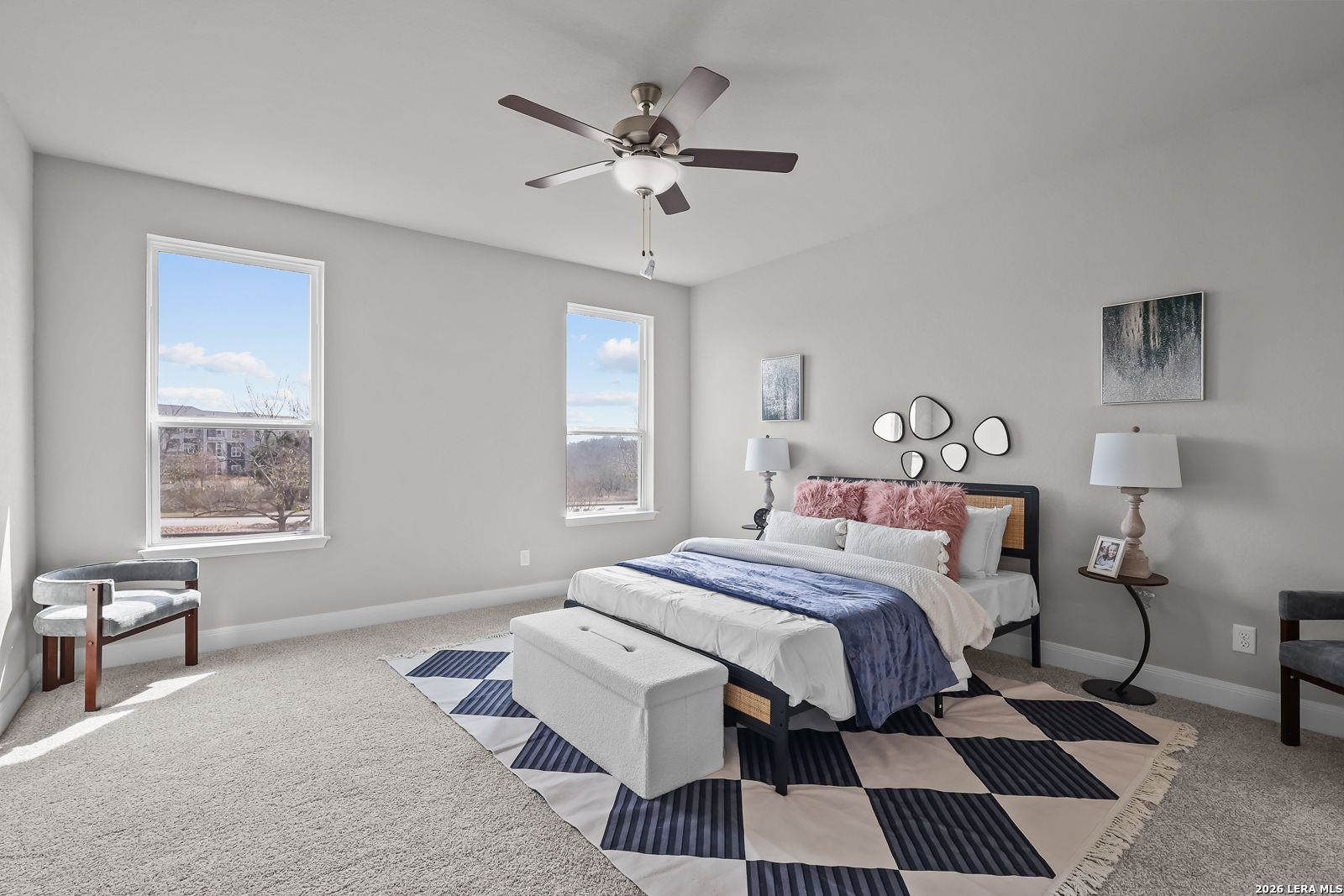 Elegant master bedroom with king bed, ceiling fan, large windows, and gray walls in Davidson Homes The Rockford G, Ladera, San Antonio