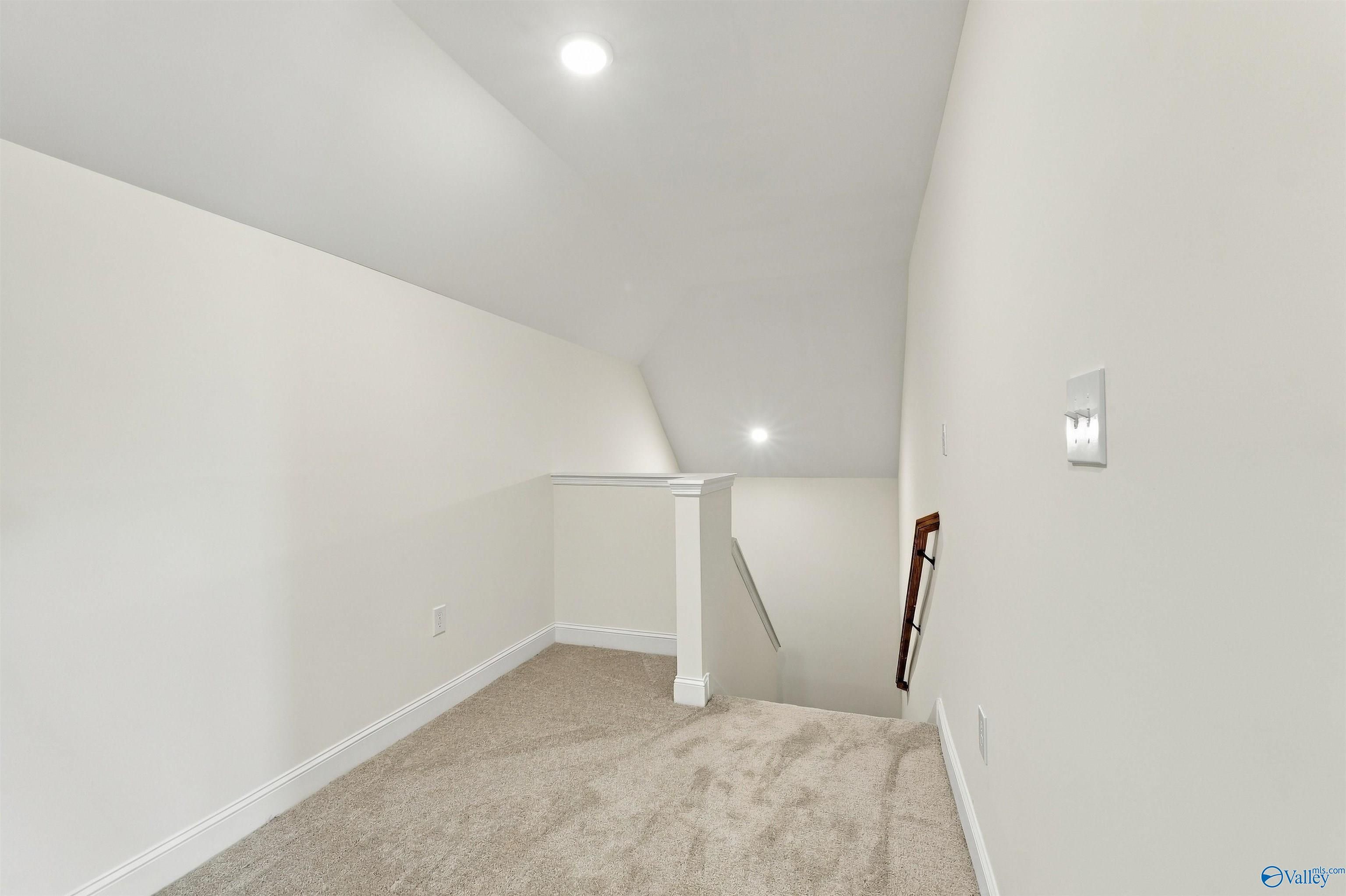 Carpeted bonus room with vaulted ceiling at top of stairs in Davidson Homes' The Valencia, Riverton Preserve, Huntsville, Alabama