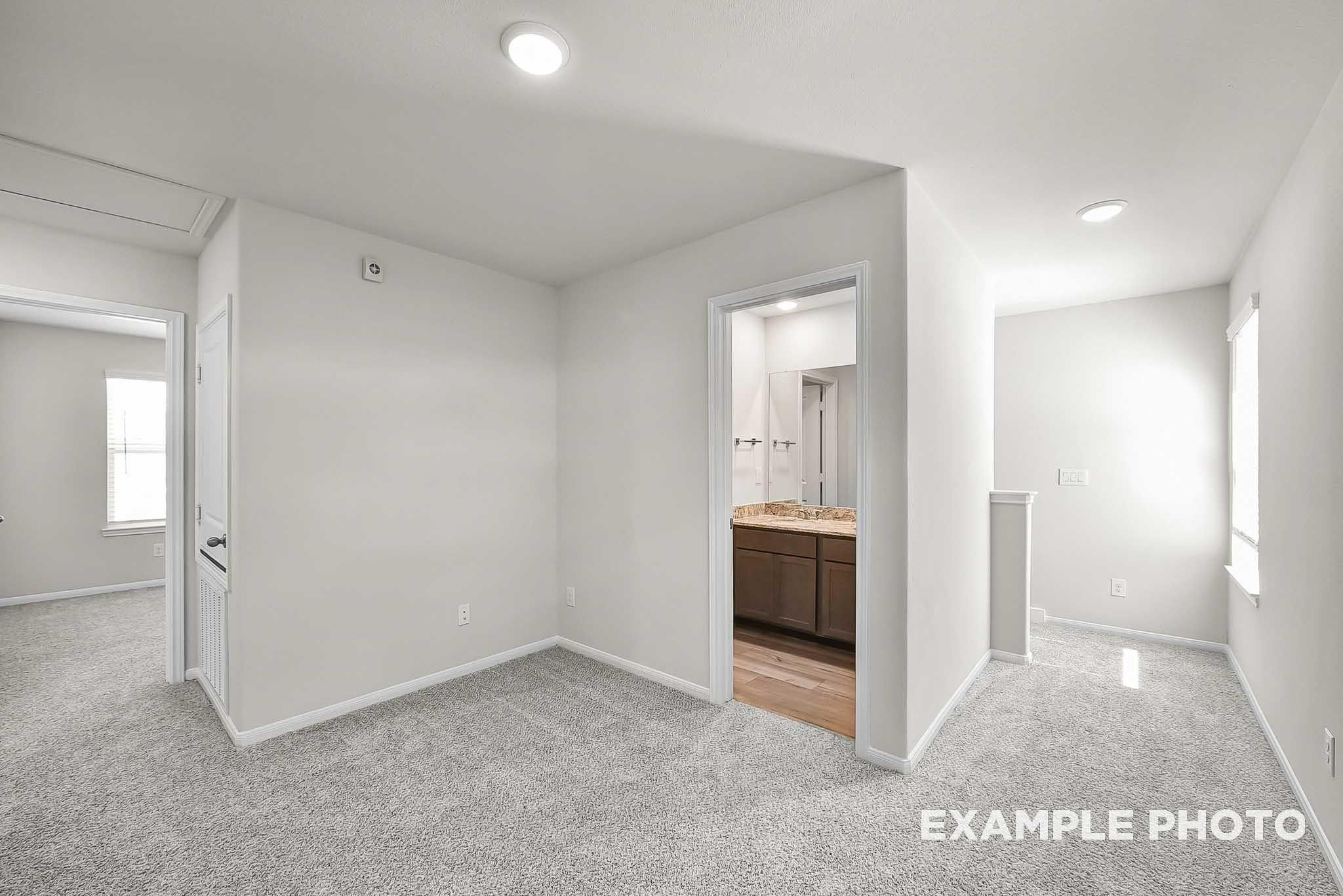 Spacious upstairs landing and hallway with plush carpet in The Blanco F floor plan at Spring Branch Crossing, Conroe, Texas.