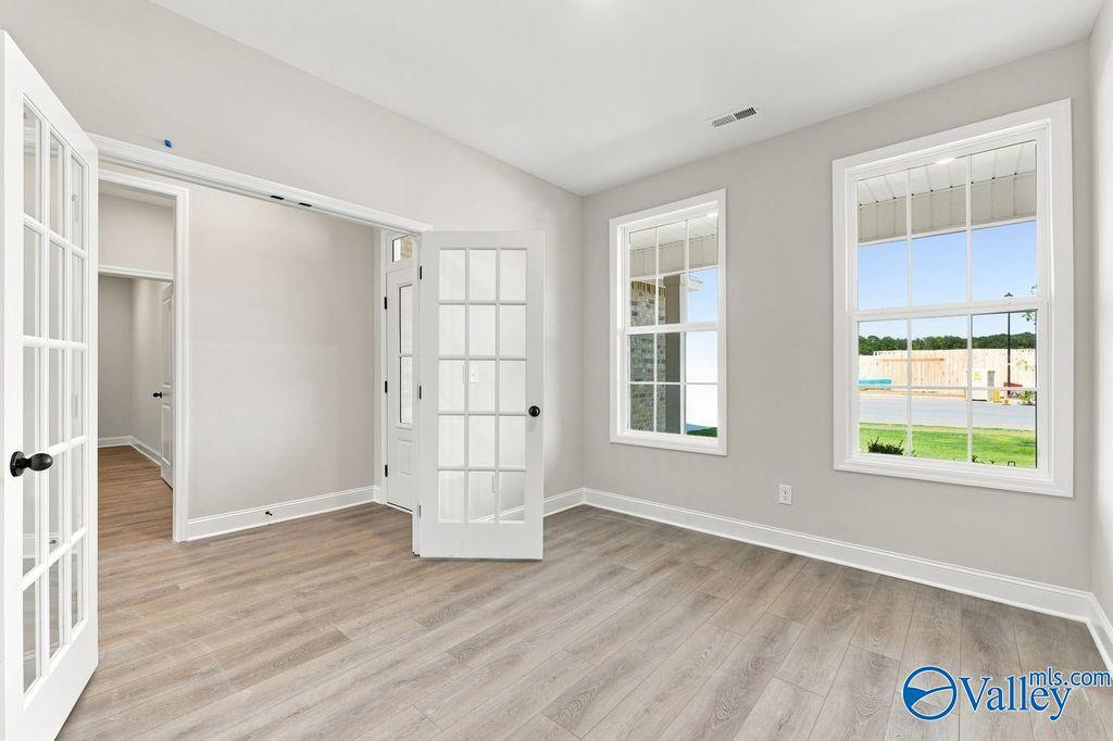 Bright flex room with French doors and wood-look flooring in Davidson Homes The Rockford floor plan at Cain Park, Hartselle, Alabama.