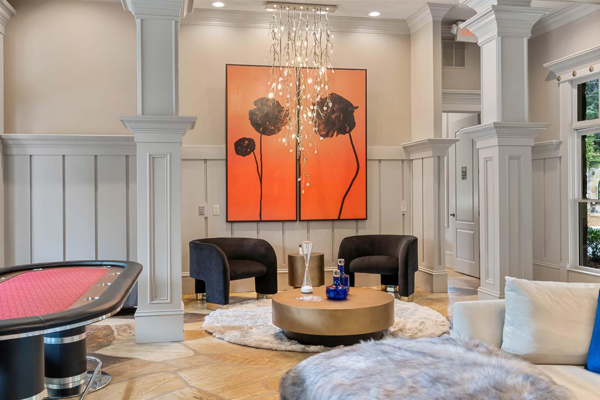 Elegant lounge with pool table and abstract orange floral art at The Village at Towne Lake in Woodstock, Georgia