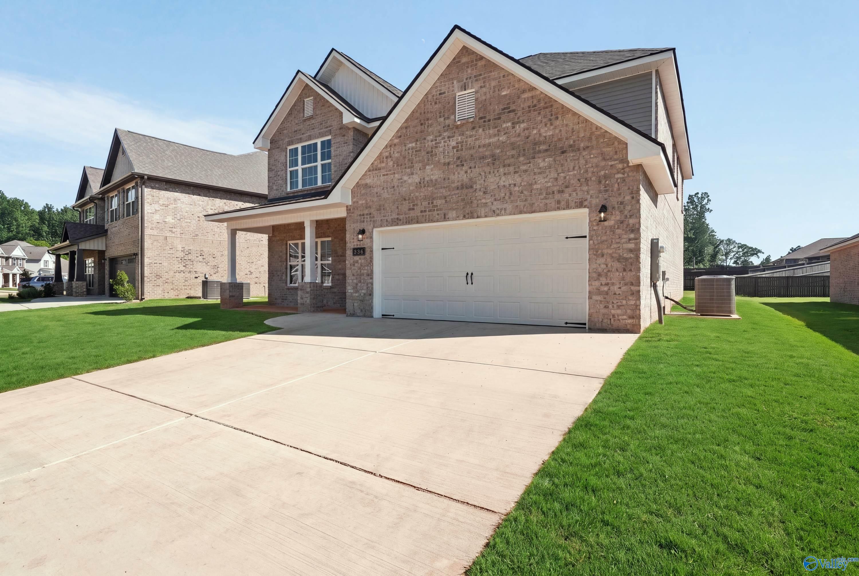 Brick 2-story home with 2-car garage and landscaped yard in Creek Grove, New Market, Alabama by Davidson Homes.
