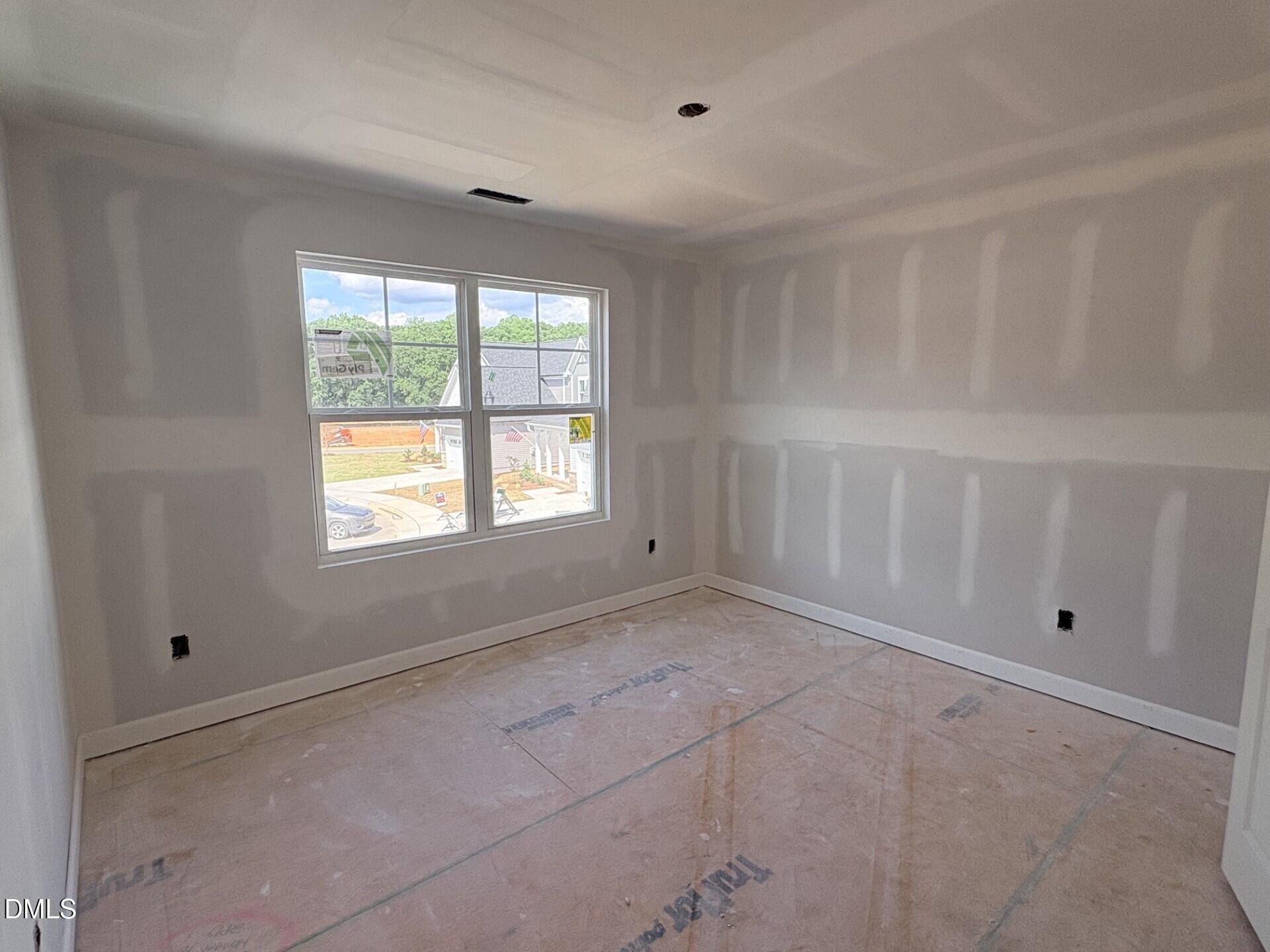 Unfinished bedroom with drywall and subfloor in The Ash C floor plan at Woodland Crossing, Zebulon, North Carolina.