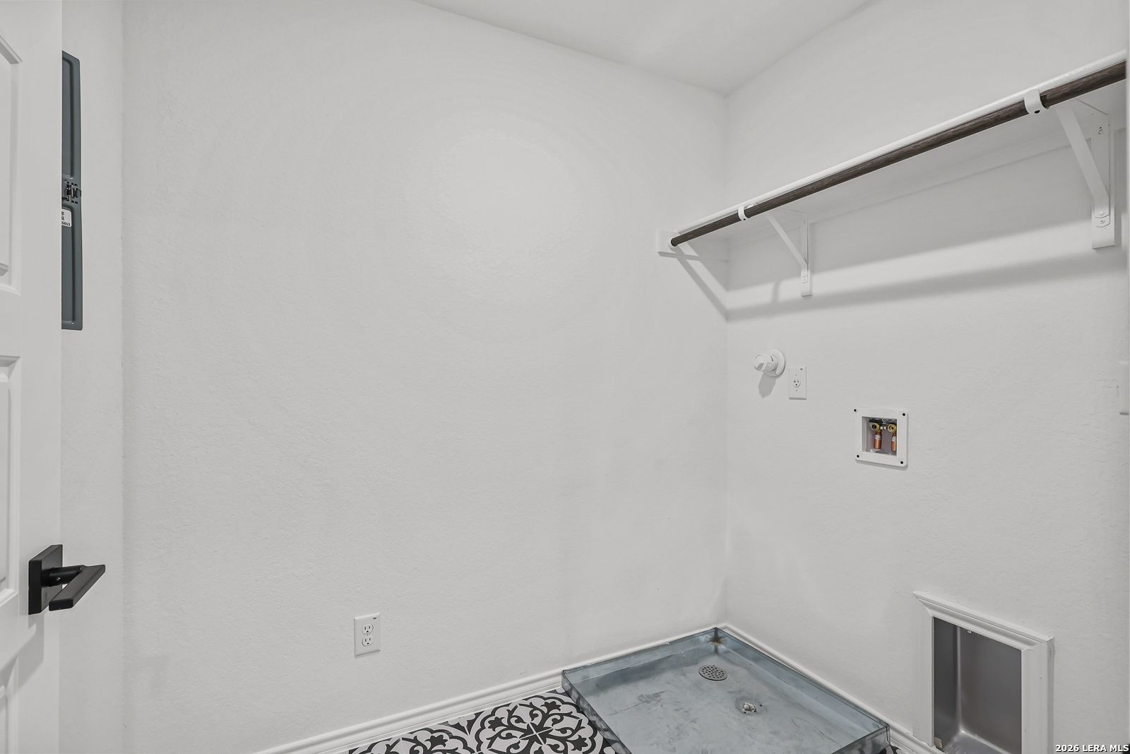 Laundry room with utility hookups and storage shelf in The Gillian C floor plan at Meadows at Oak Creek, San Antonio.
