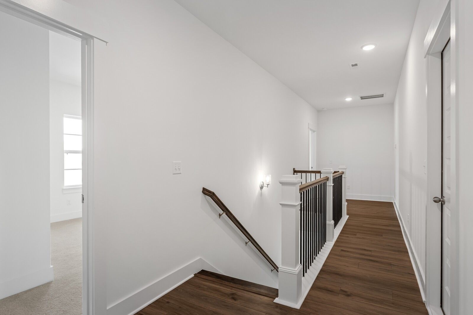 Elegant upstairs hallway with hardwood floors and wrought iron staircase in The Hawkins 4-bedroom home, Shelton Square, Murfreesboro, TN