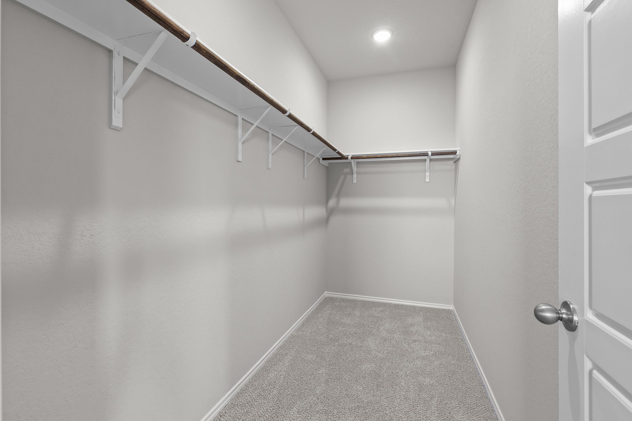 Spacious walk-in closet in the master suite of The Colorado B featuring ample shelving and neutral carpeting.
