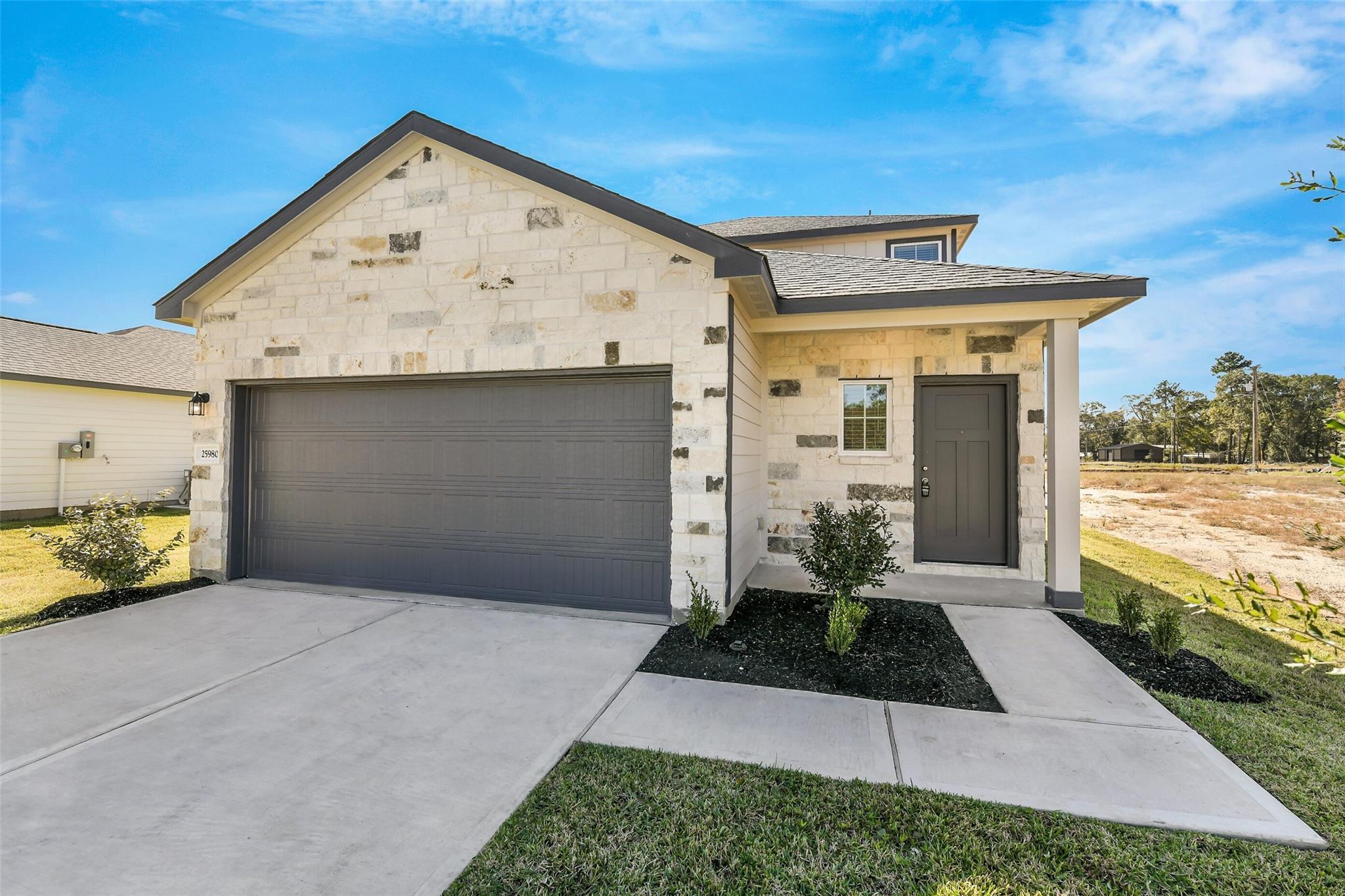 Modern two-story stone-accented home with 2-car garage and driveway in Liberty Estates, Cleveland, Texas by Davidson Homes