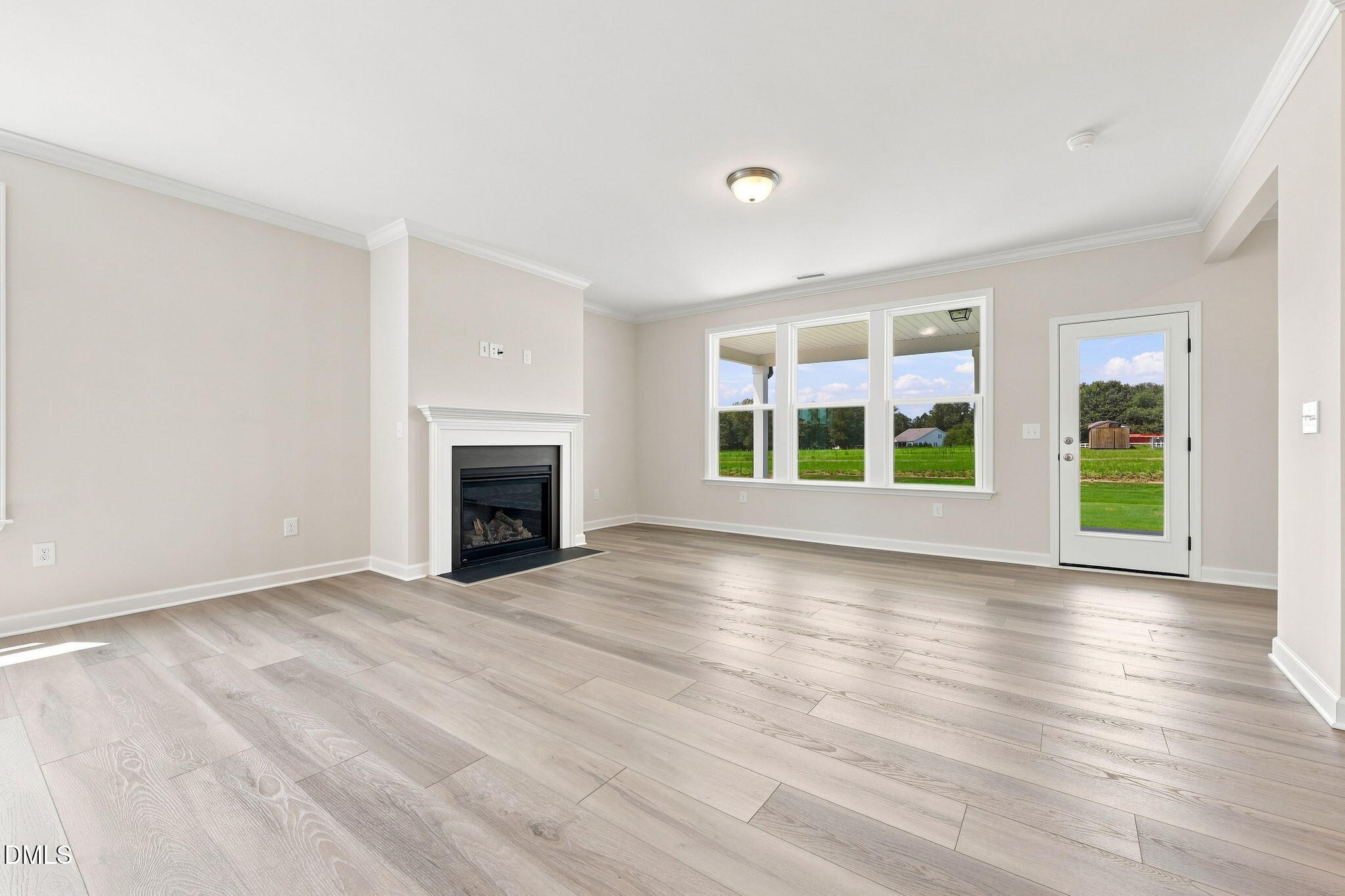 Bright living room with fireplace and wood-look floors in The Magnolia B floor plan at Retreat at North Main, Lillington.