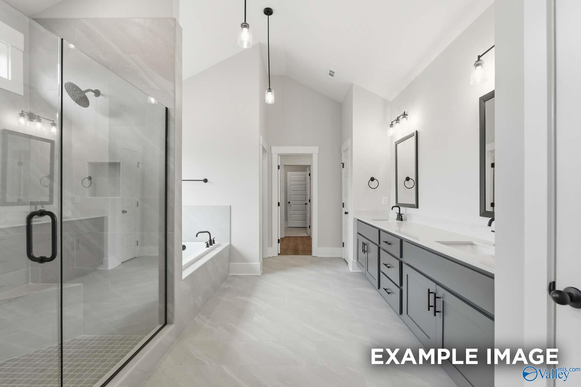 Modern primary bathroom with dual-sink vanity, glass shower, and soaking tub in The Finleigh by Davidson Homes, Briercreek.