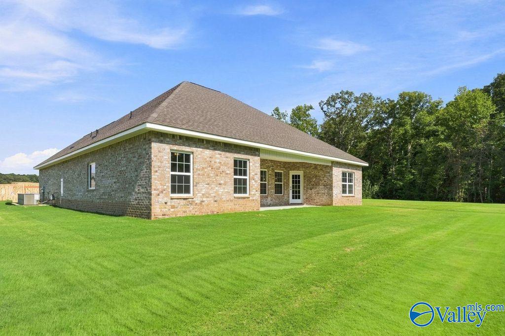 Brick exterior of Davidson Homes' The Rockford floor plan with covered patio and large backyard in Cain Park, Hartselle, Alabama