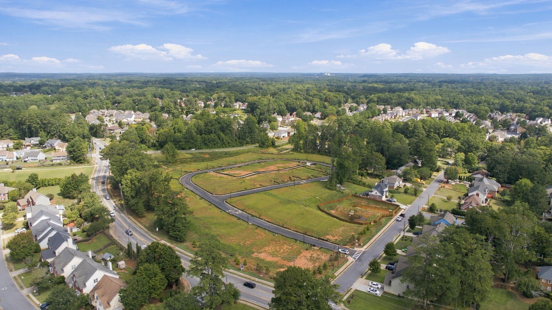 Aerial view of Alford at Bethesda community site in Lawrenceville, Georgia by Davidson Homes with new streets and surrounding neighborhood