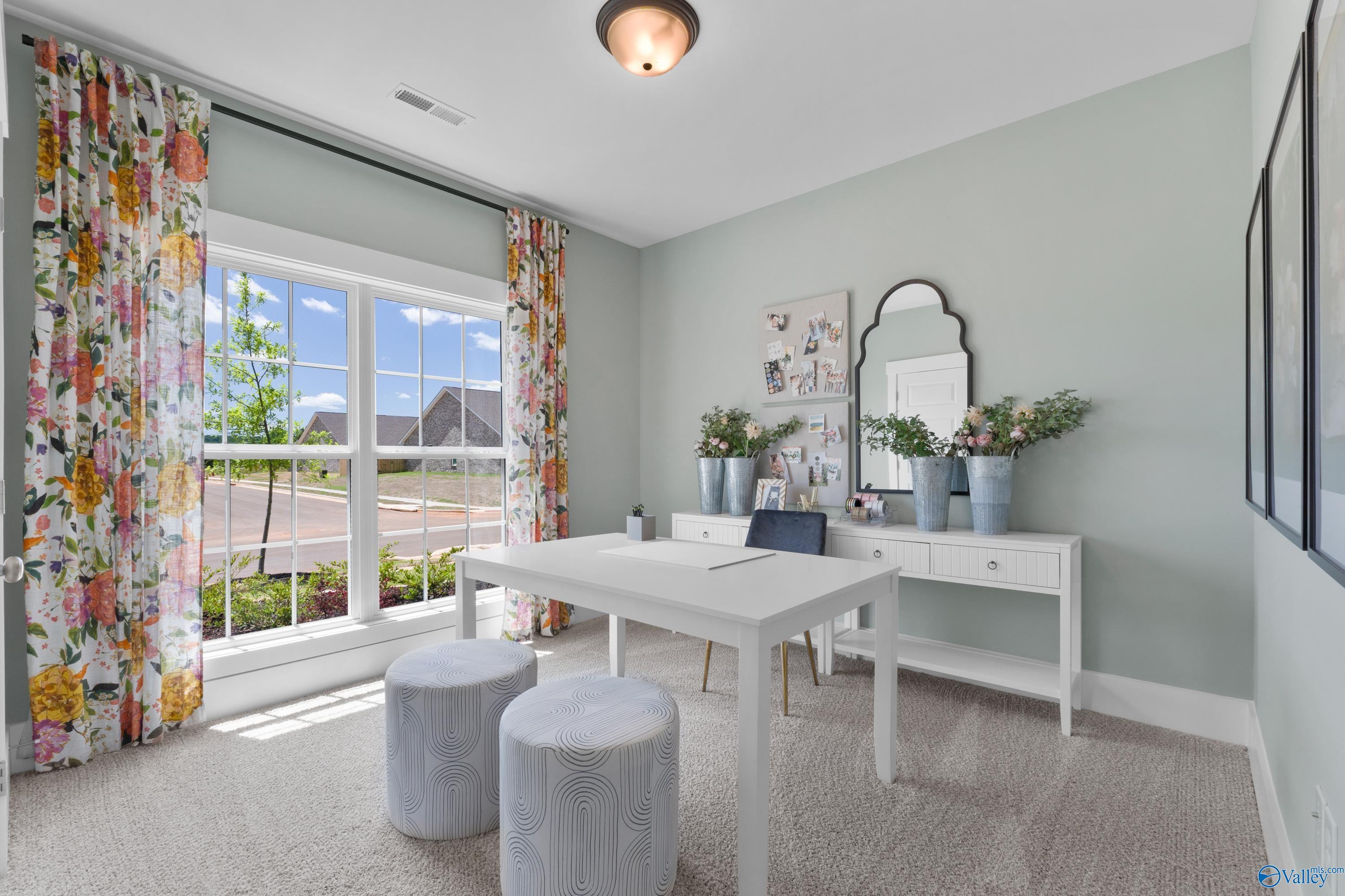 Bright home office with white desk and floral curtains in The Franklin floor plan by Davidson Homes, Hollon Meadow, Decatur.