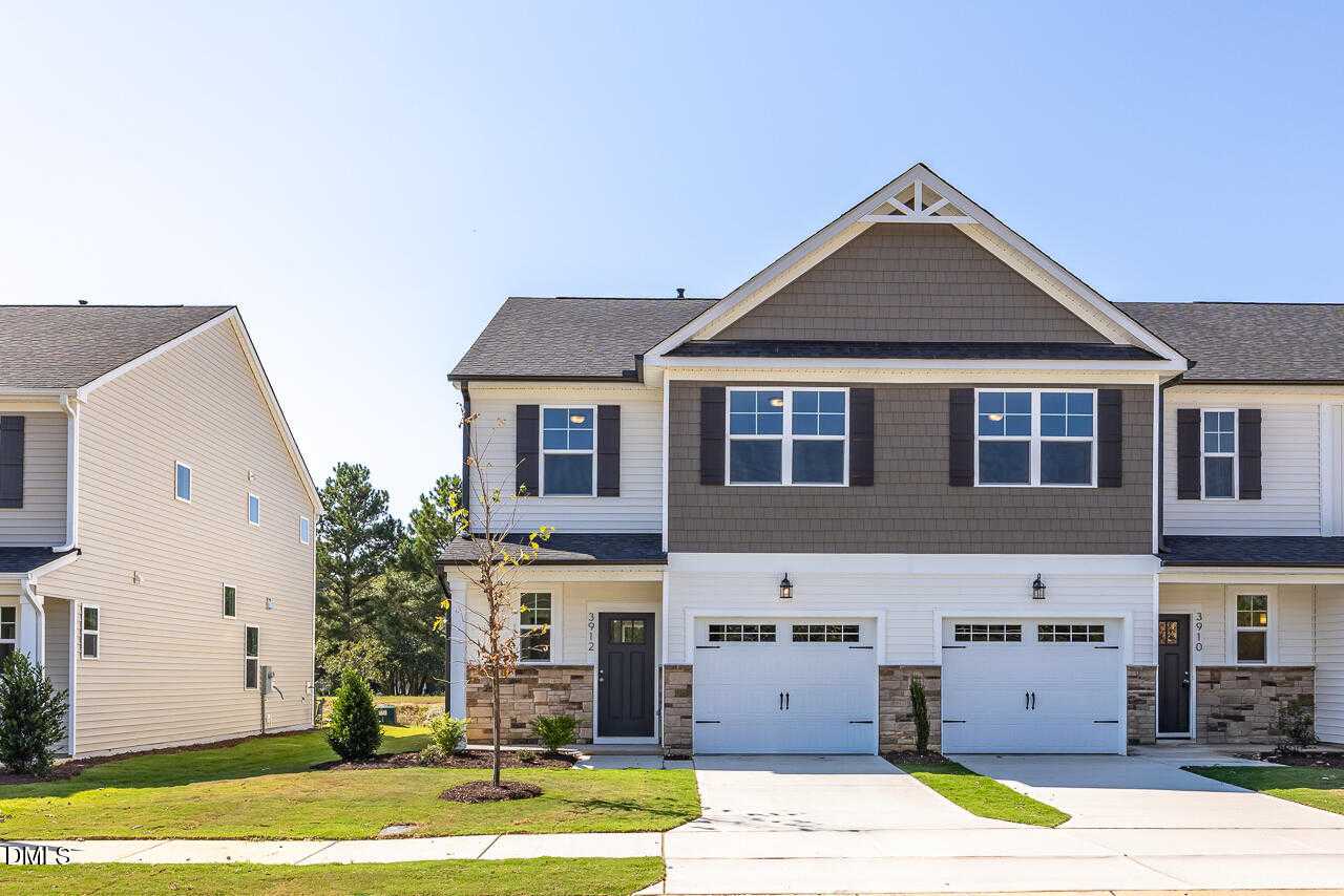 Two-story Graham Exterior home by Davidson Homes in Springvale, Fuquay-Varina, NC: gray siding, brick accents, two-car garage, driveway, lush lawn