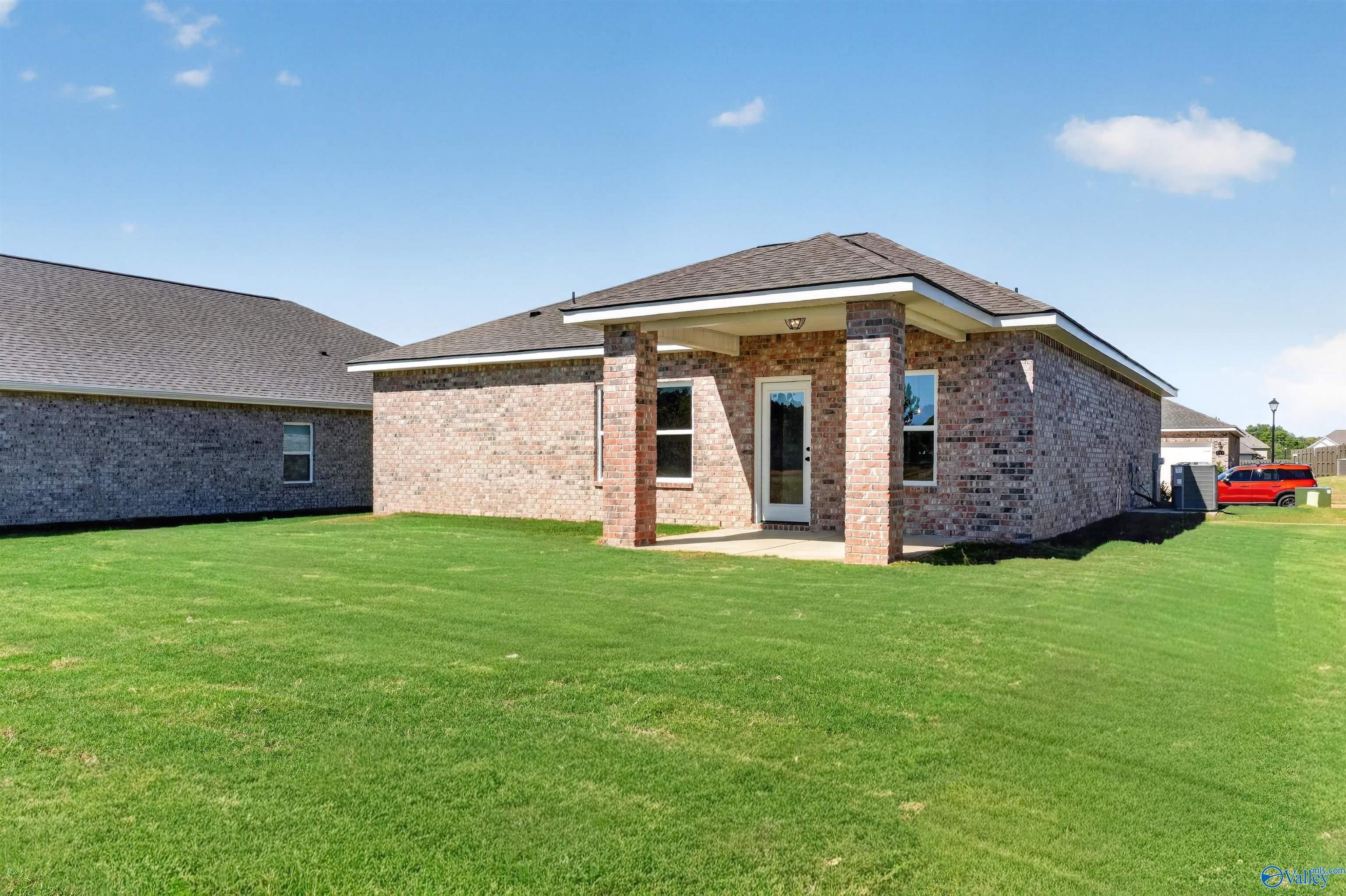 Brick single-story home with covered porch and large green backyard in Clearview, Hazel Green, Alabama by Davidson Homes
