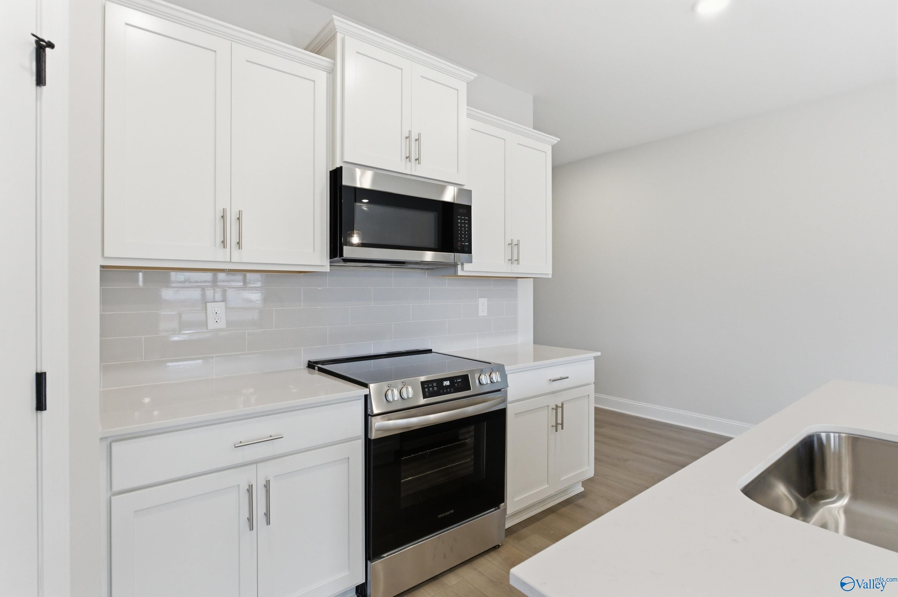 Modern white kitchen with shaker cabinets, stainless steel appliances, subway tile backsplash in The Daphne C 4-bedroom home, Huntsville AL