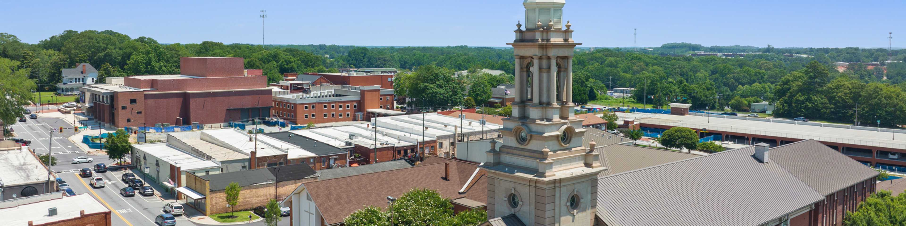 Aerial view of Grayson downtown with historic steepled church, brick buildings, and tree-lined streets