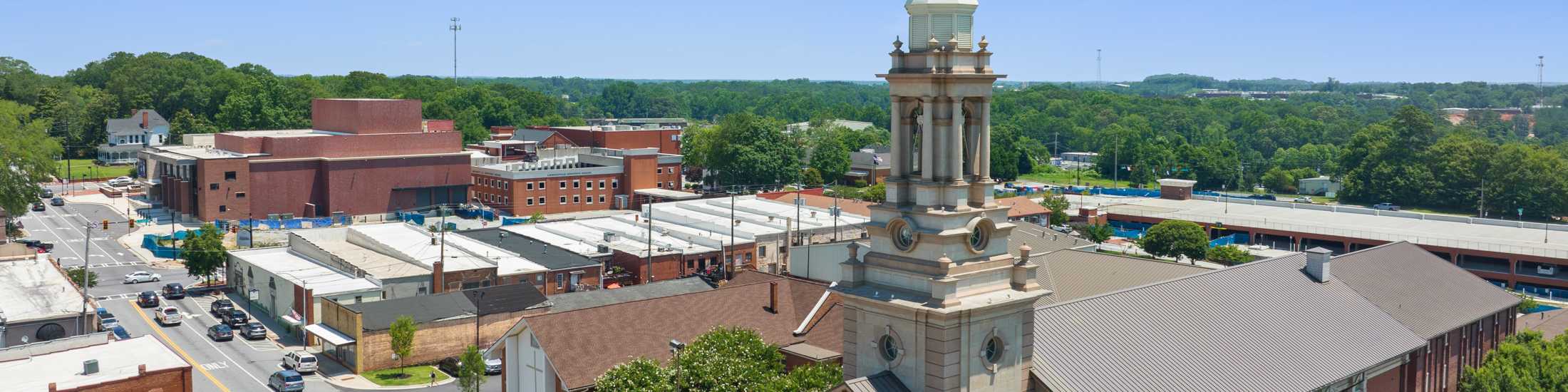 Aerial view of Grayson downtown with historic steepled church, brick buildings, and tree-lined streets