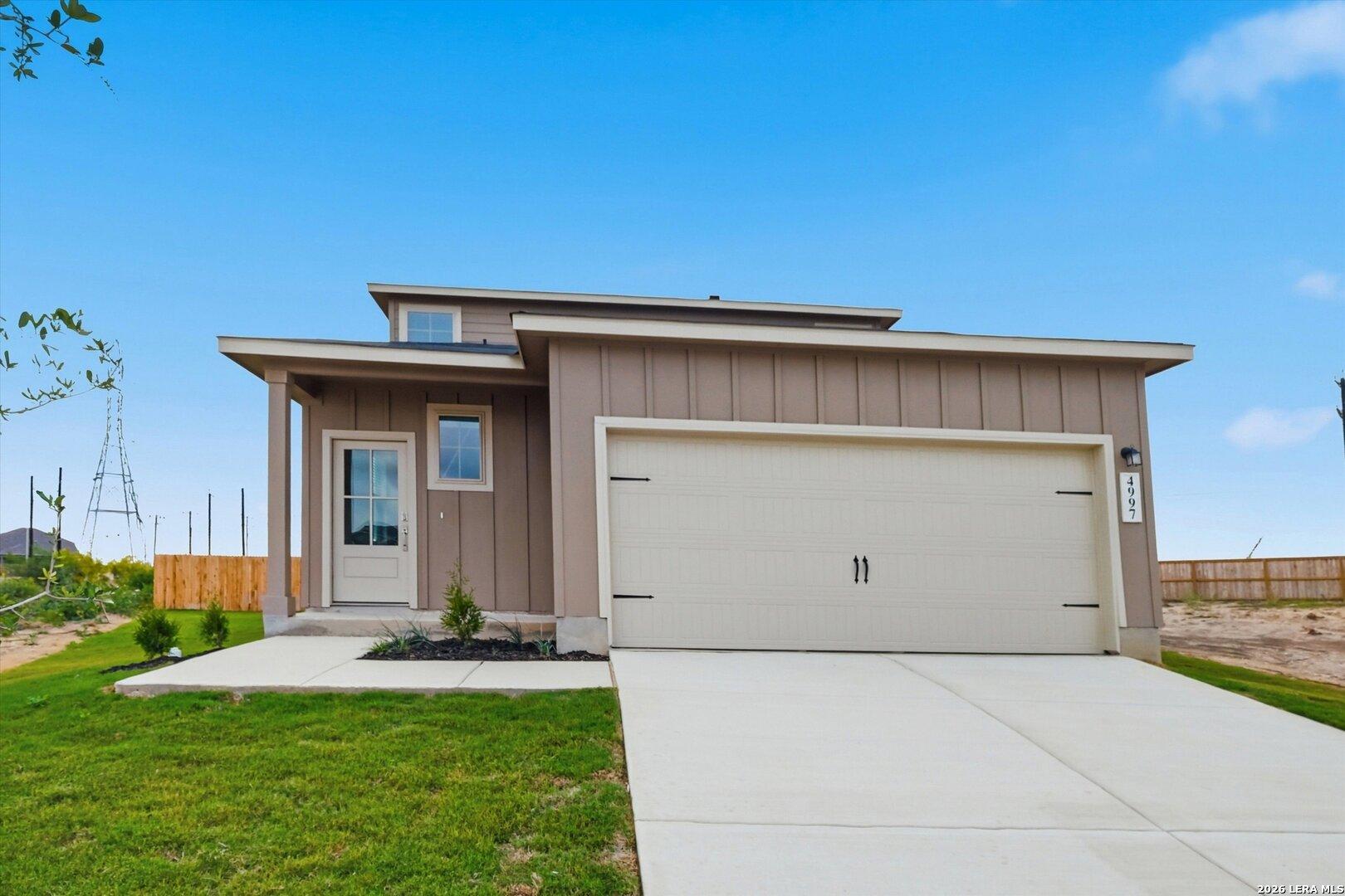 Modern two-story Sabine A home by Davidson Homes with beige siding, two-car garage, and front porch in Agave, San Antonio, Texas