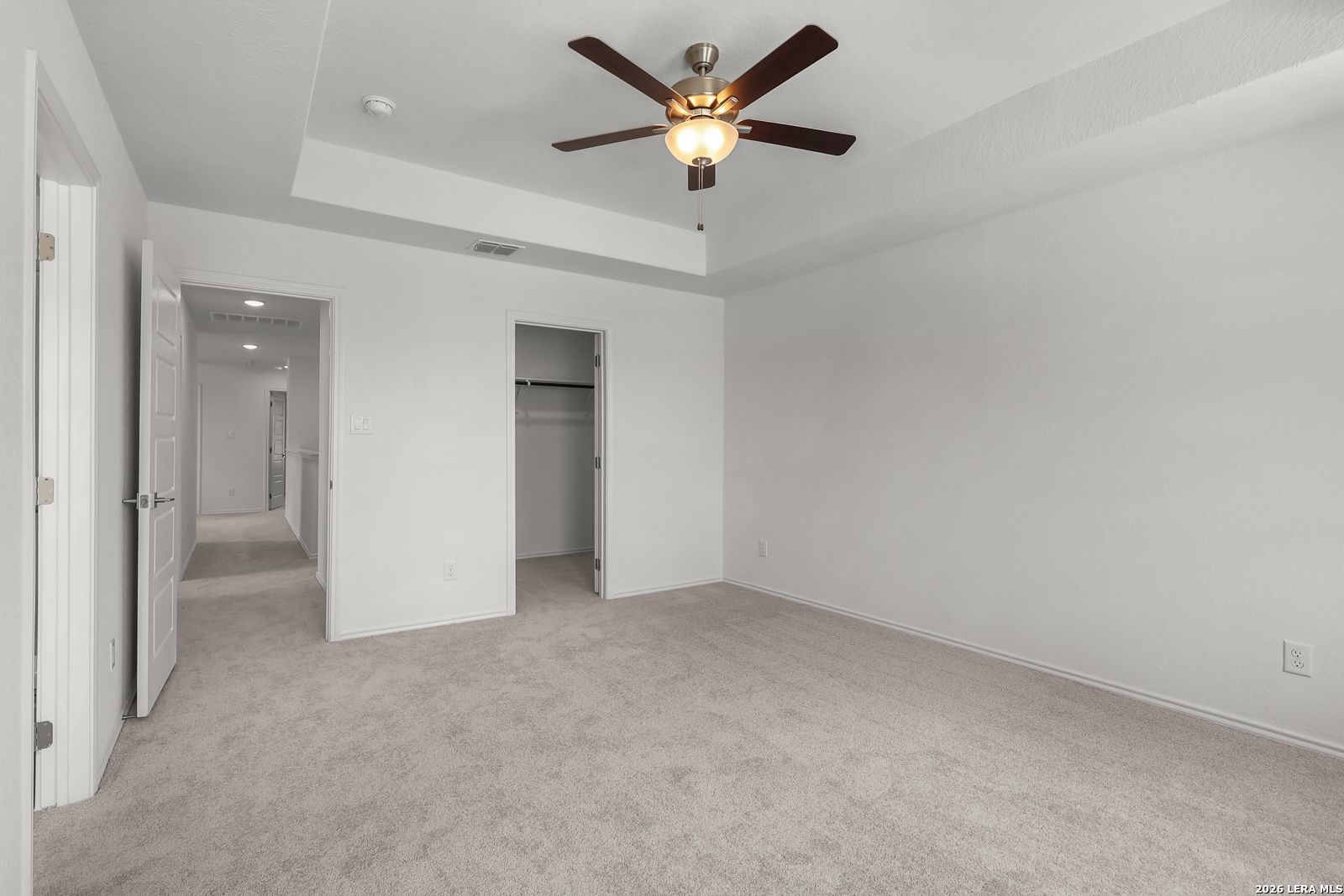 Spacious bedroom with tray ceiling and ceiling fan in The Gillian C floor plan at Meadows at Oak Creek, San Antonio, Texas.