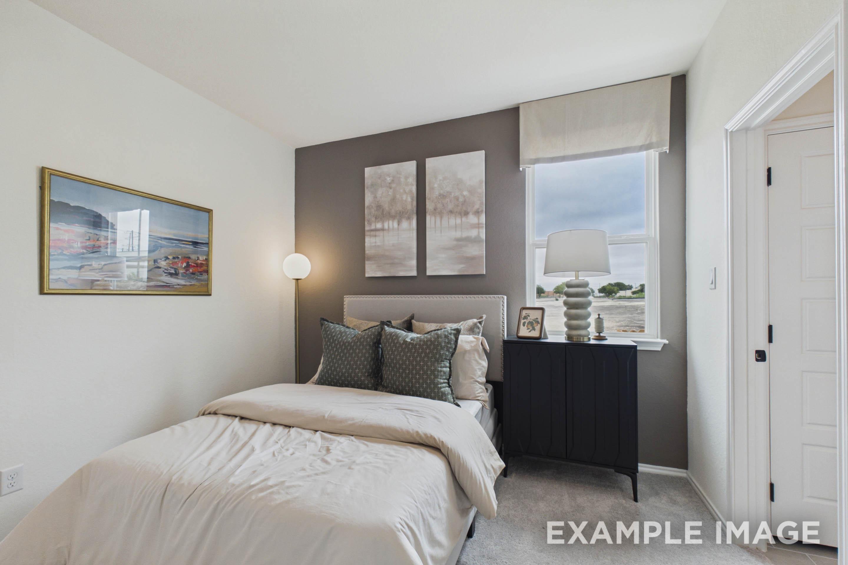 Cozy guest bedroom in The Laurel G home design featuring modern decor, neutral bedding, and a stylish accent wall.