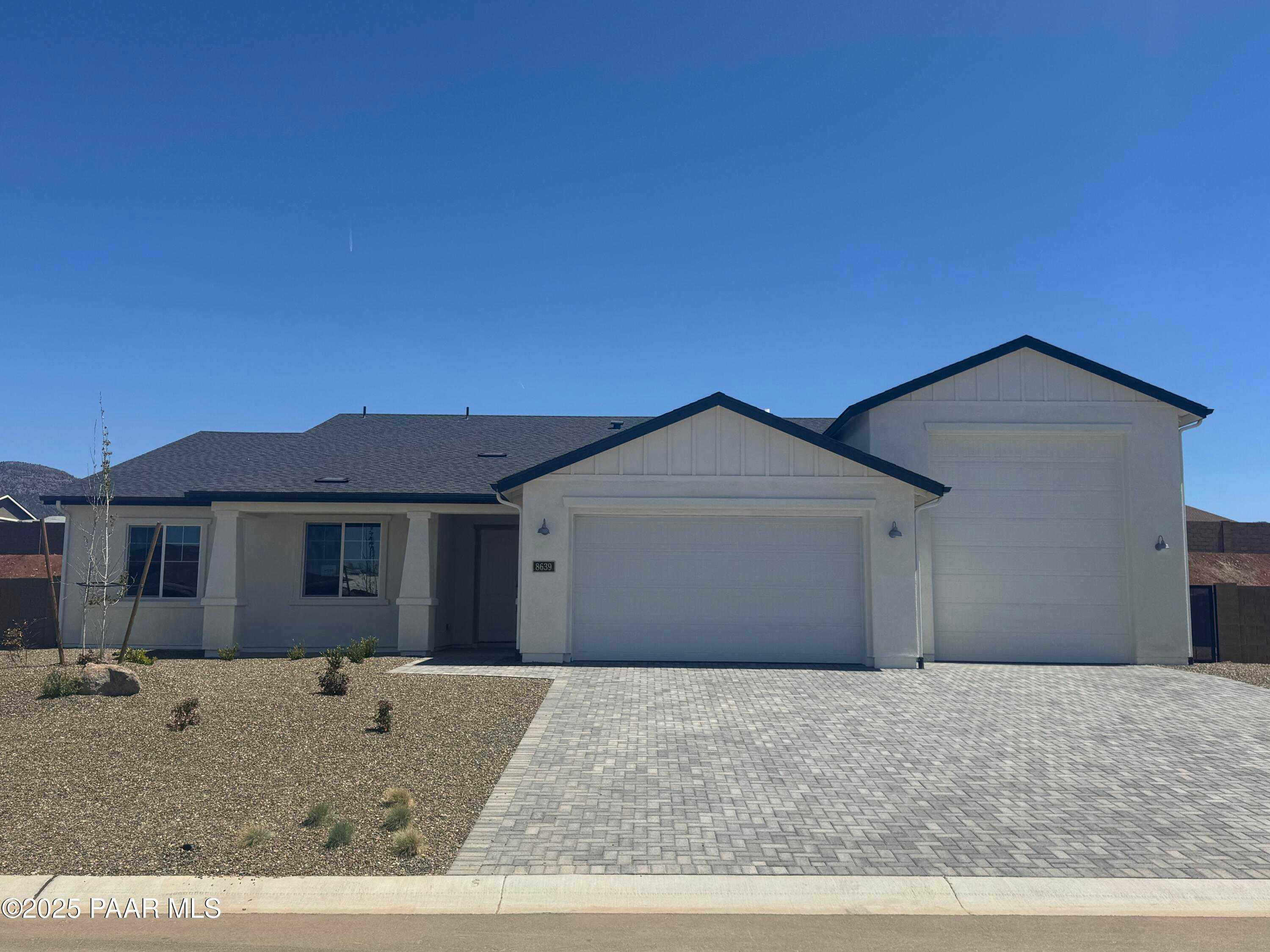 Modern single-story home with white siding, black roof, 2-car garage, and desert yard in Morningstar, Prescott Valley, Arizona