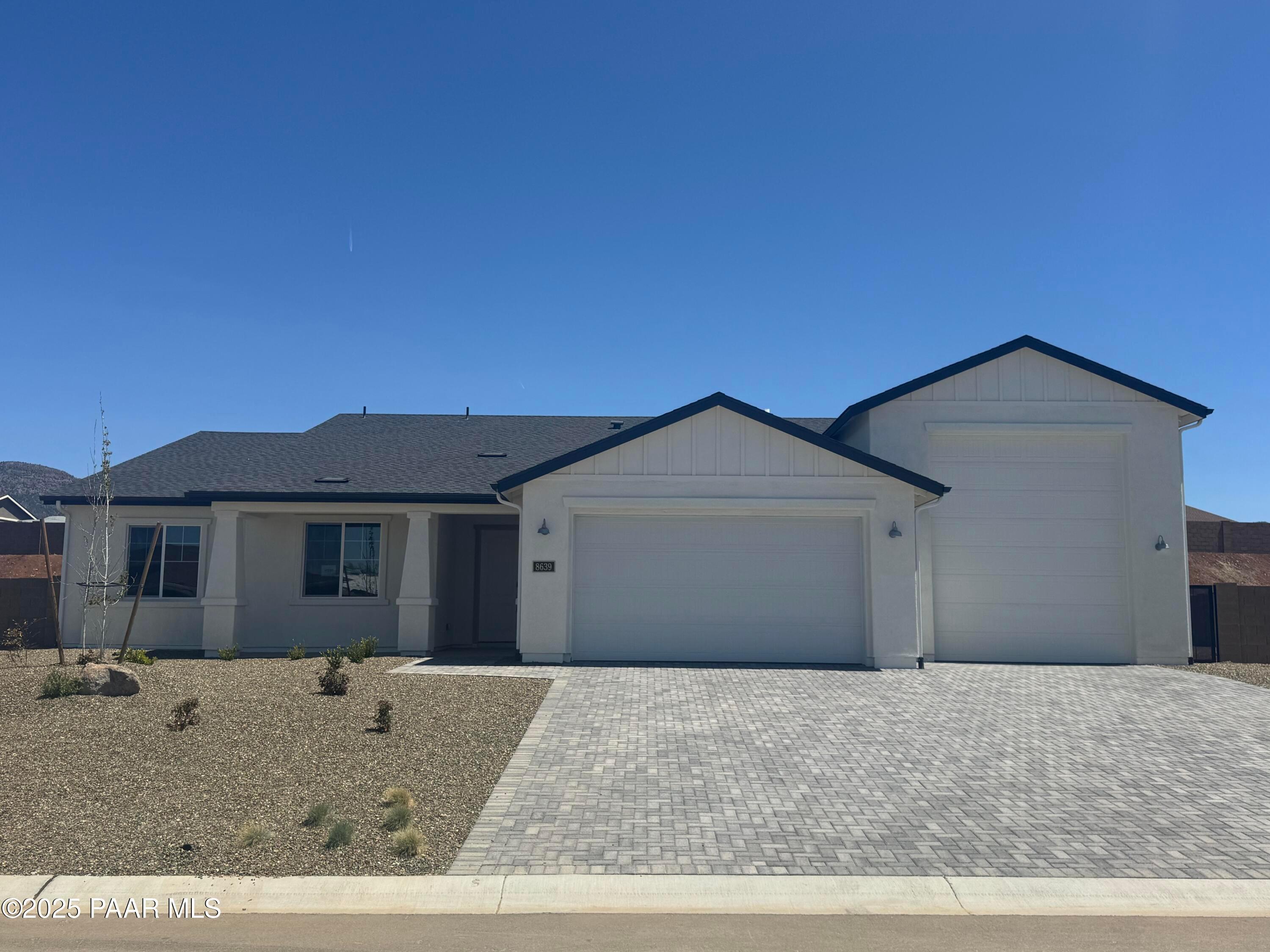 Modern single-story home with white siding, black roof, 2-car garage, and desert yard in Morningstar, Prescott Valley, Arizona