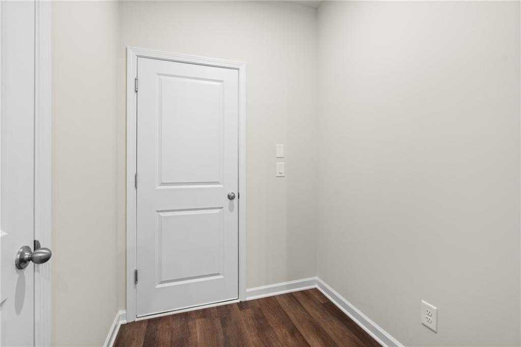 White paneled door in neutral-toned room with laminate wood floors and electrical outlets in 3-bed Marion B home, Kennesaw GA