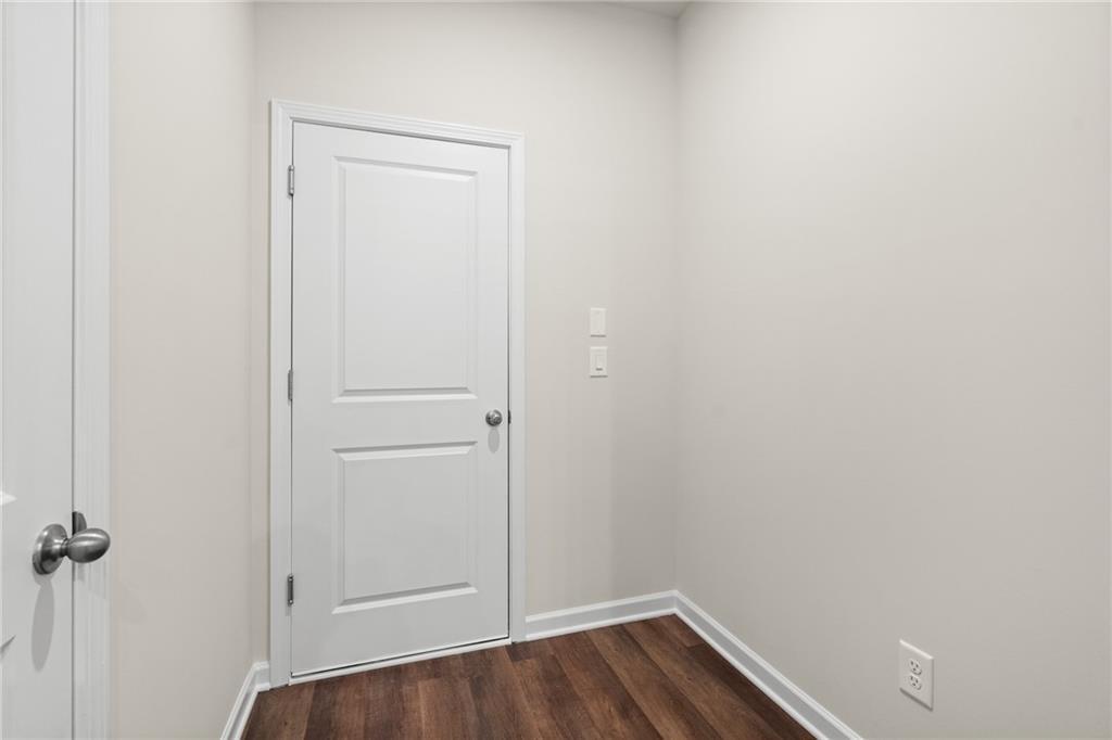 White paneled door in neutral-toned room with laminate wood floors and electrical outlets in 3-bed Marion B home, Kennesaw GA