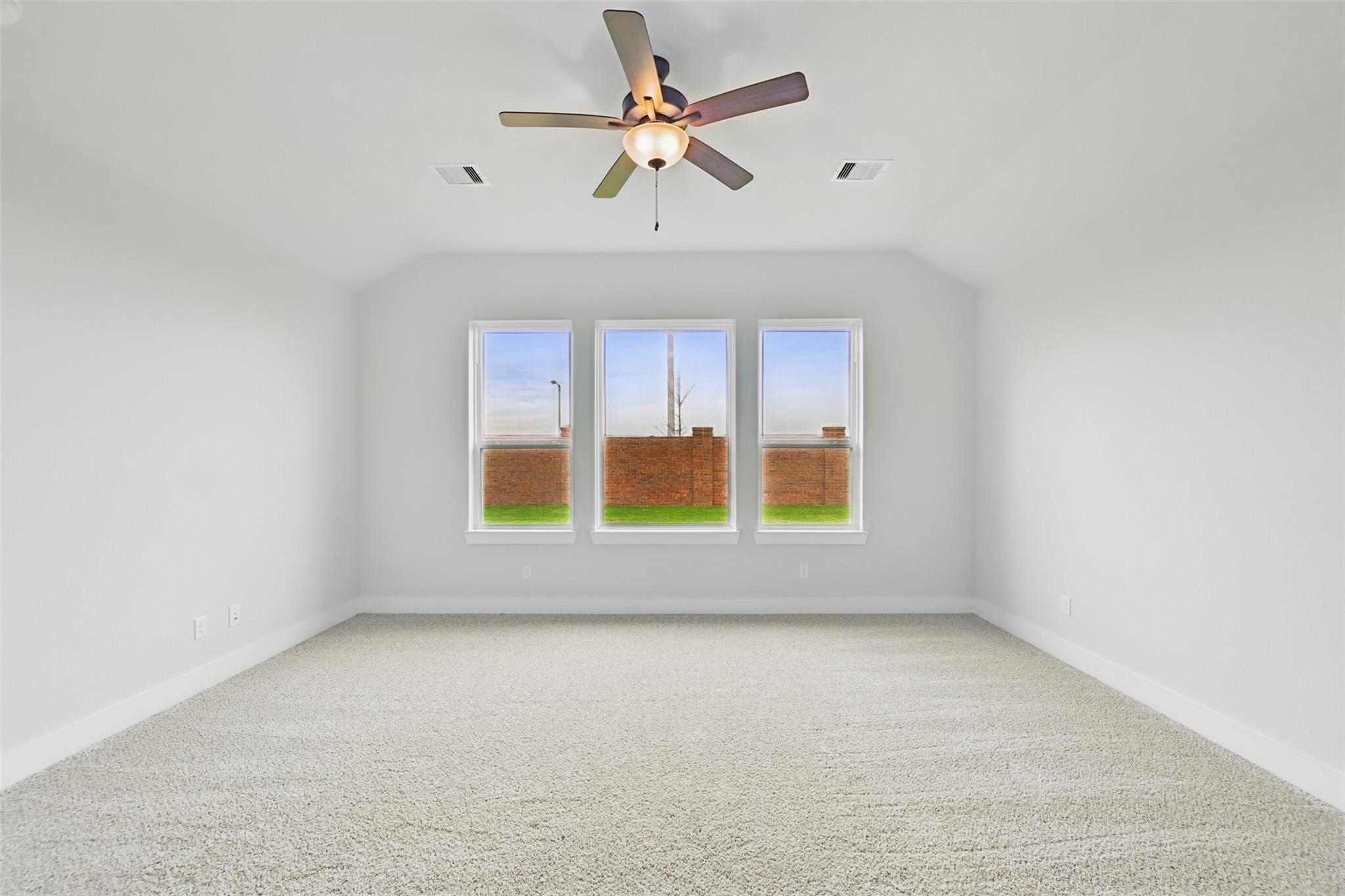 Empty bedroom with ceiling fan, large windows, and backyard view in Davidson Homes The Victoria C, Lago Mar, Texas City, Texas