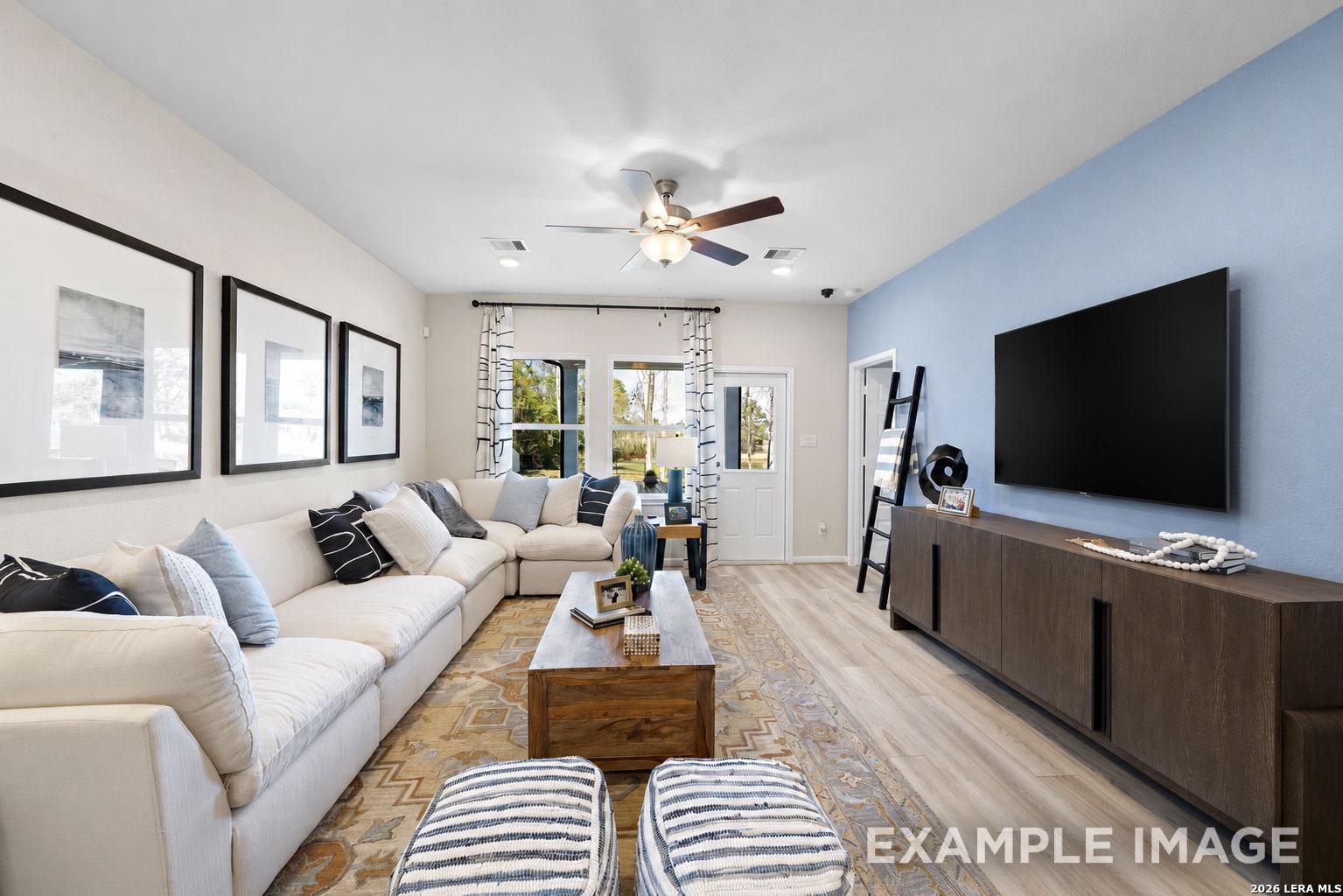 Cozy living room with sectionals and blue accent wall in The San Marcos F floor plan by Davidson Homes, San Antonio, Texas.