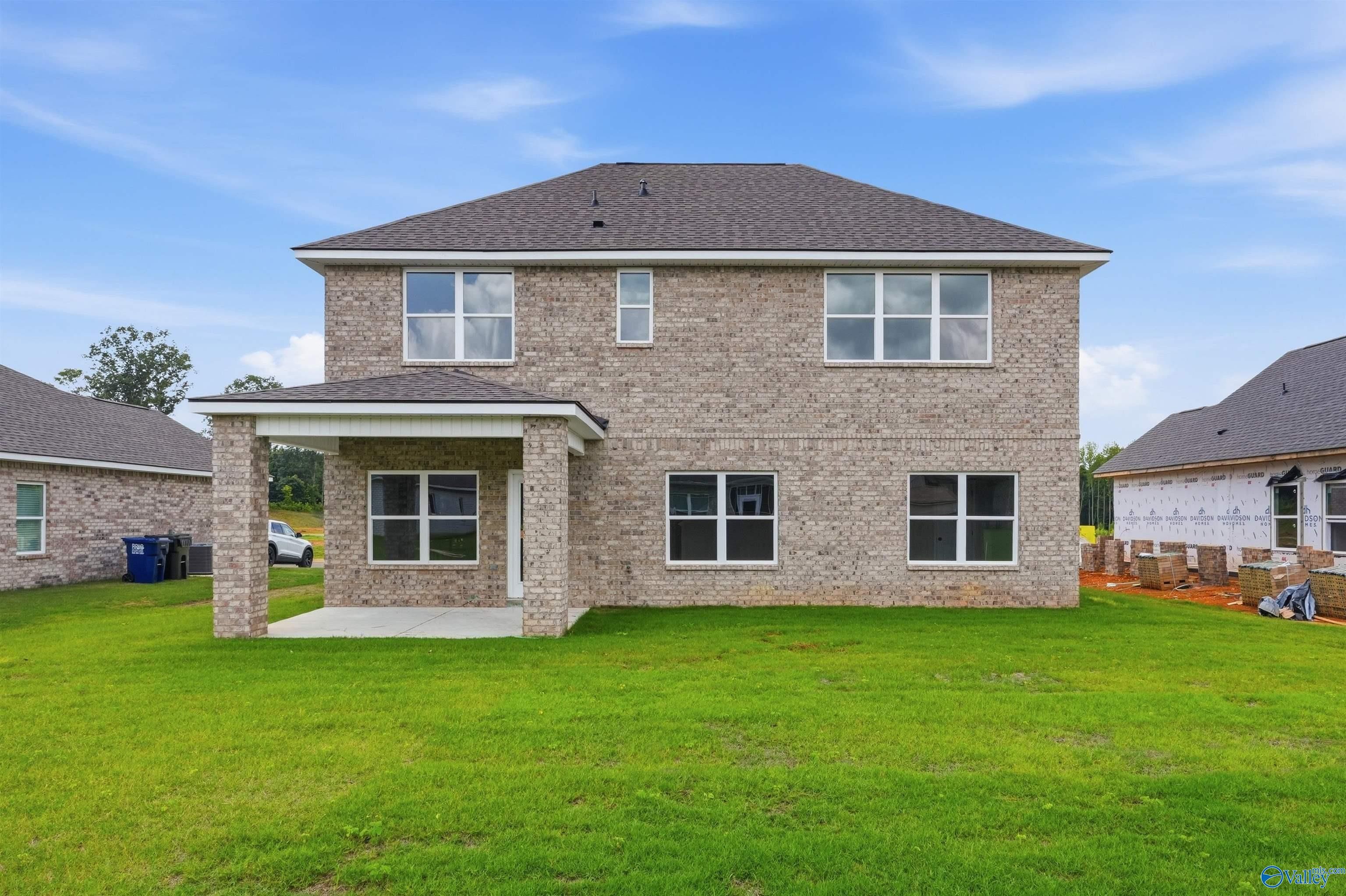 Rear view of The Shelby A floor plan featuring a brick exterior and covered patio in Wood Trail, Toney, Alabama.
