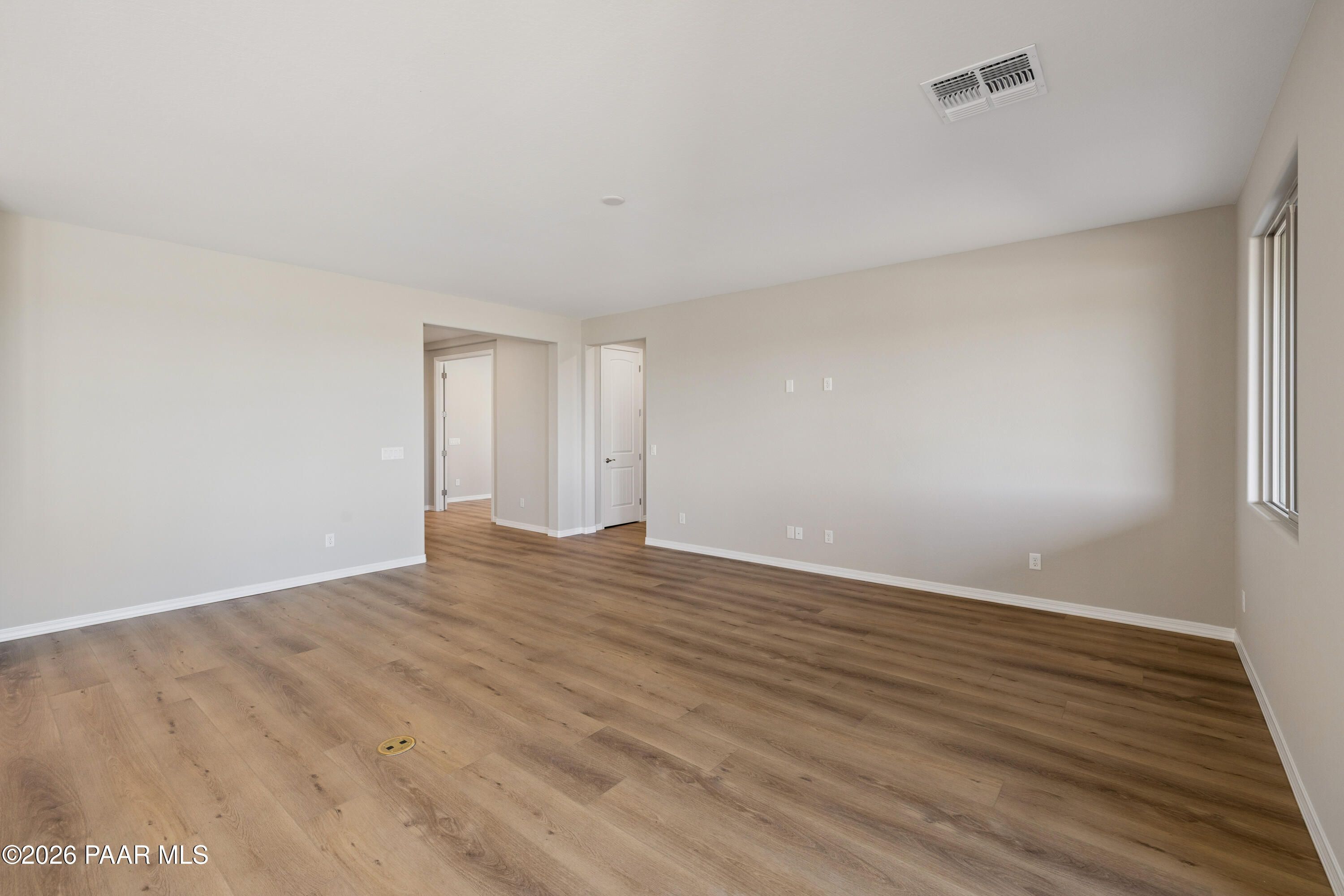 Spacious open foyer with luxury vinyl plank flooring and neutral walls in Davidson Homes The Harmony A, Prescott Valley, Arizona
