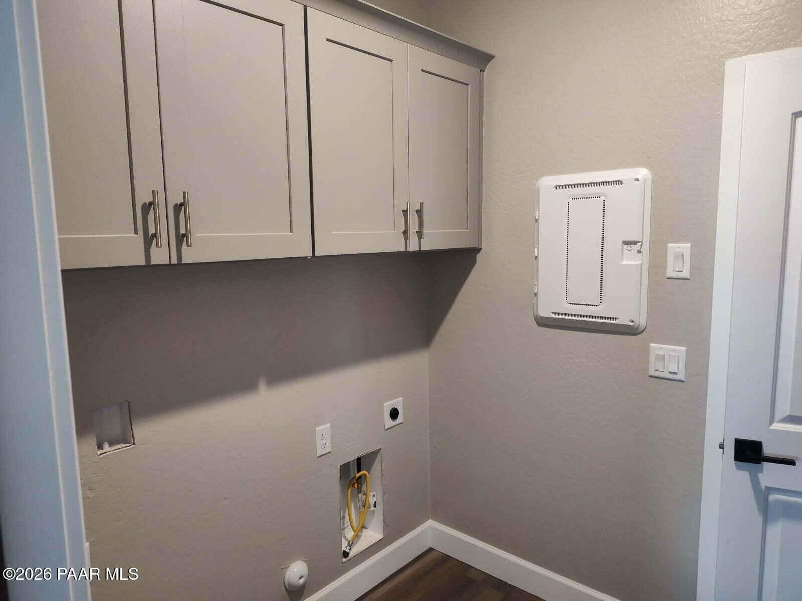 Modern laundry room with gray upper cabinets, utility sink, electrical panel in Davidson Homes The Harmony C, Prescott Valley, AZ