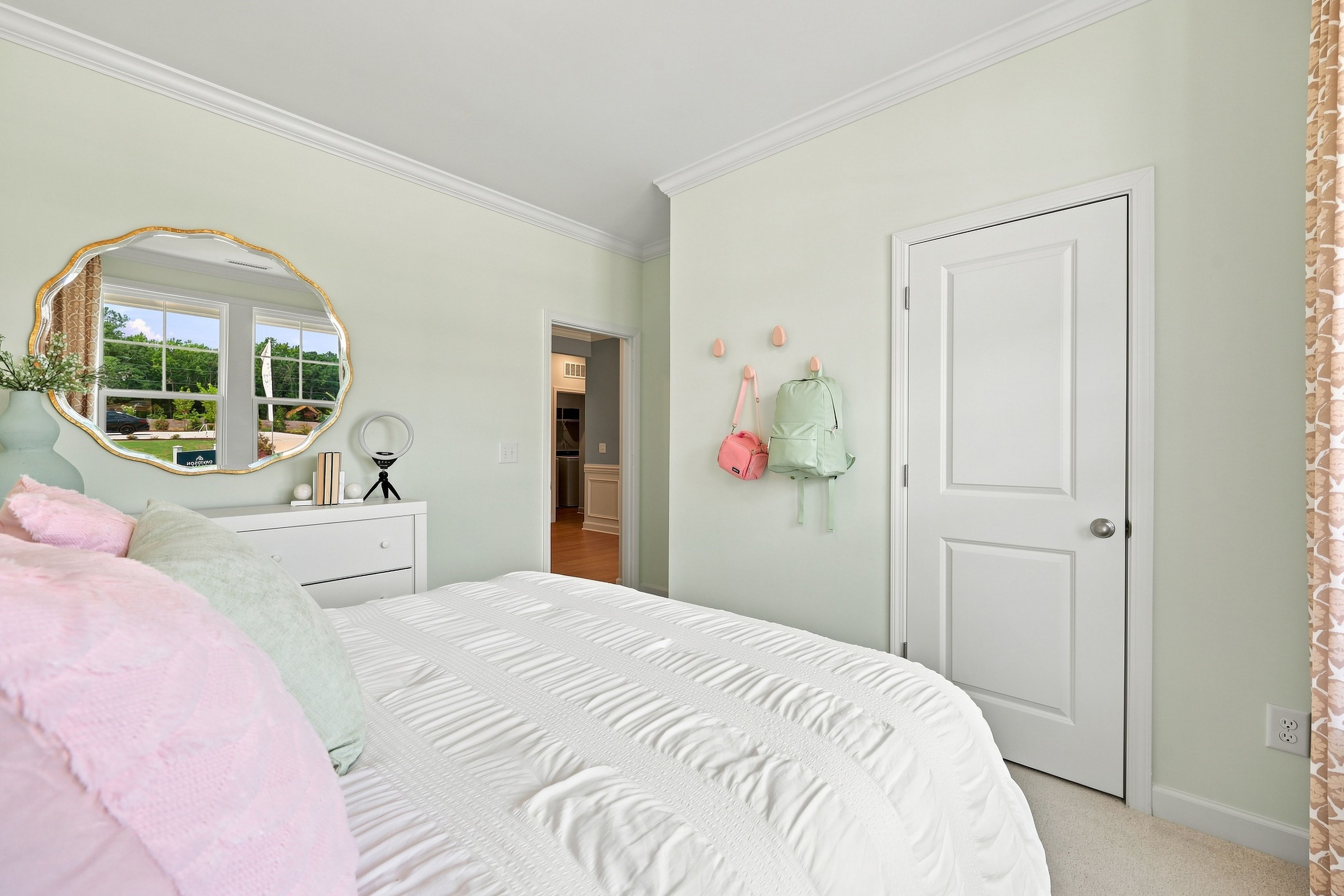 Bright bedroom in The Daphne home design featuring a white dresser, arched mirror, and spacious closet in Lillington, NC.