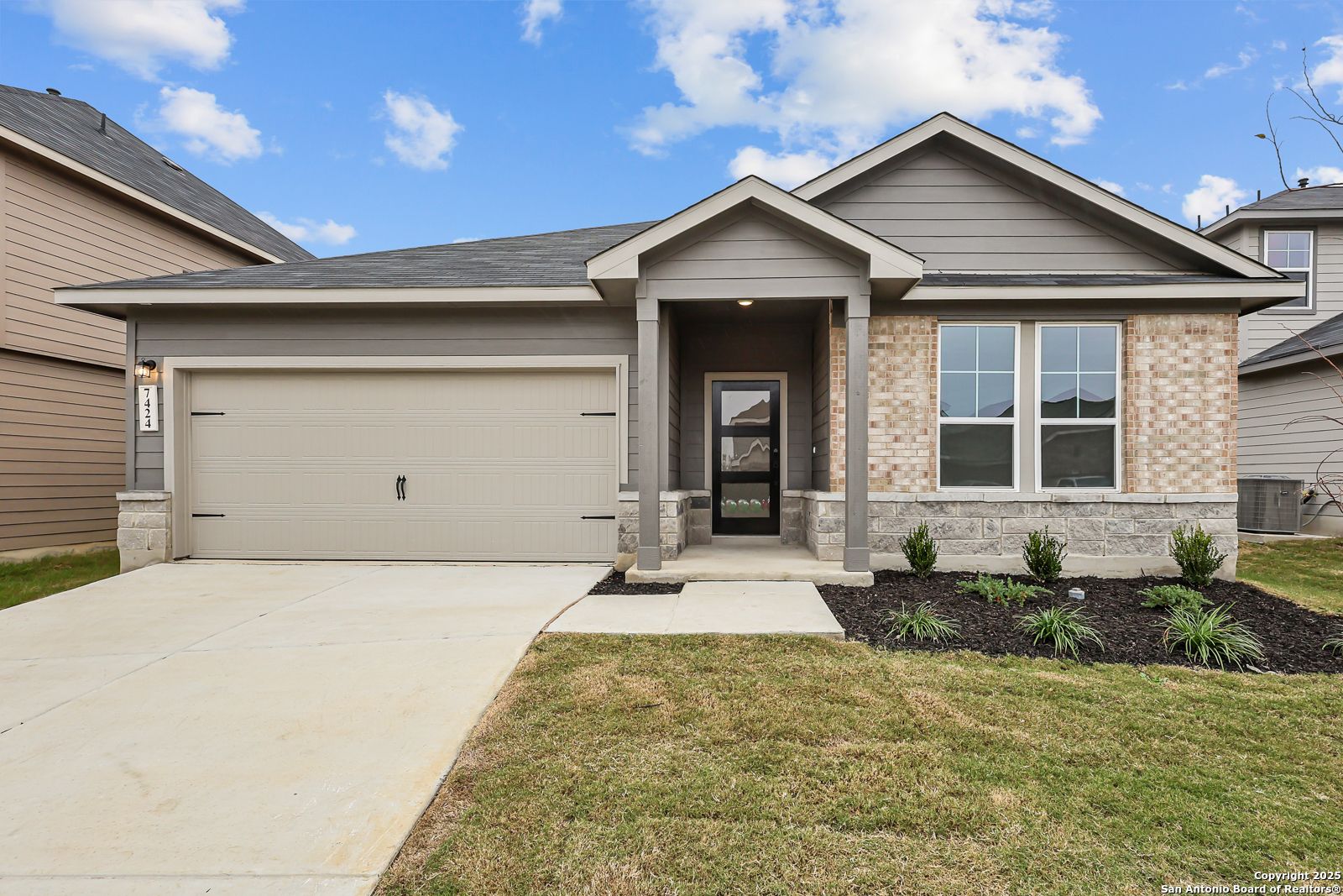Modern single-story 4-bedroom home exterior with gray brick siding, 2-car garage, and covered porch in Horizon Pointe, Converse, Texas
