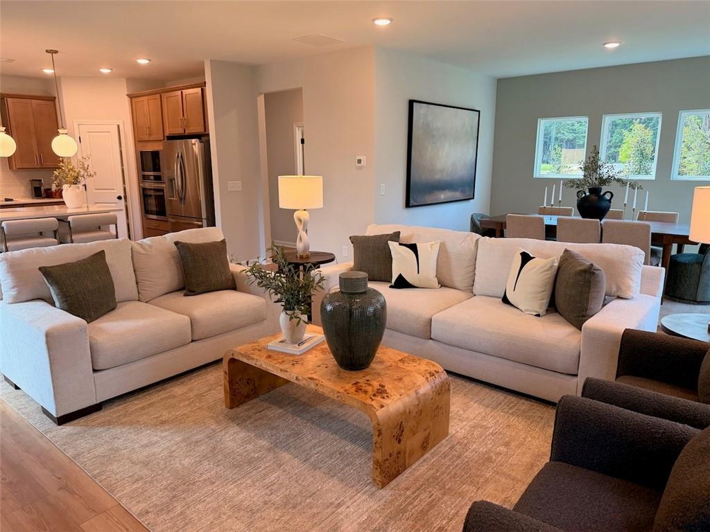 Open-concept living room with cream sofas and burl wood coffee table in Davidson Homes Pinecrest J, Cartersville, GA