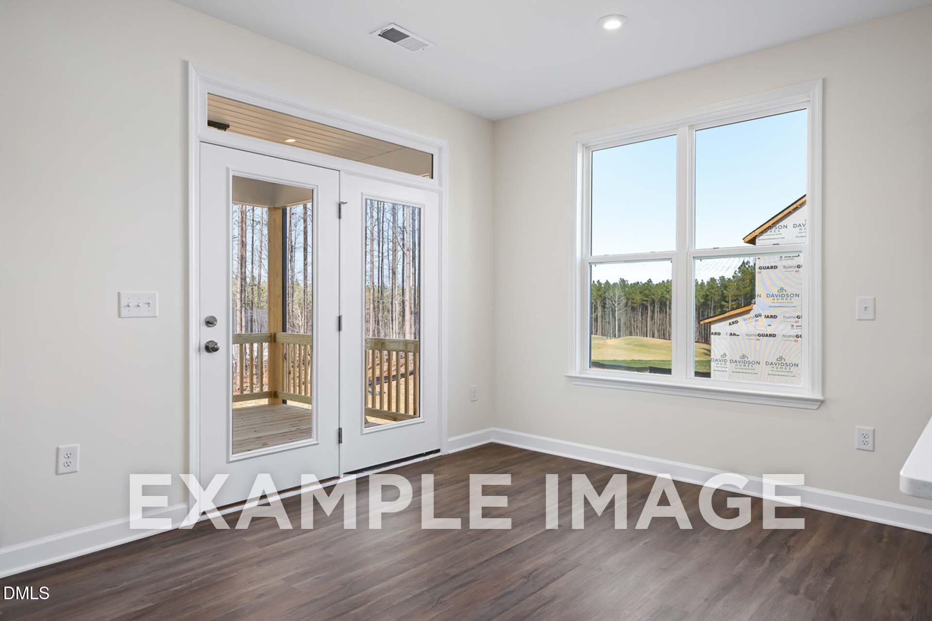 Bright room with French doors to deck overlooking wooded backyard in Davidson Homes The Ash B, Woodland Crossing, Zebulon, NC
