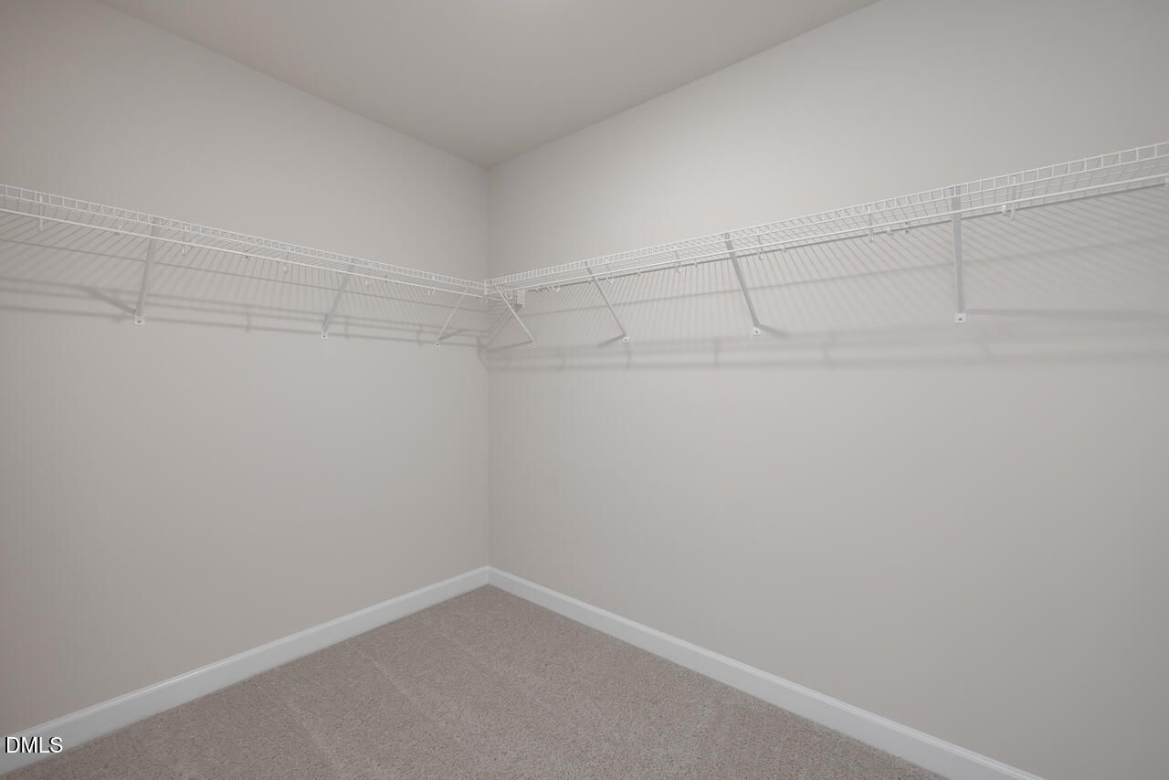 Walk-in closet with white wire shelving in The Graham floor plan at Springvale, Fuquay-Varina, North Carolina.