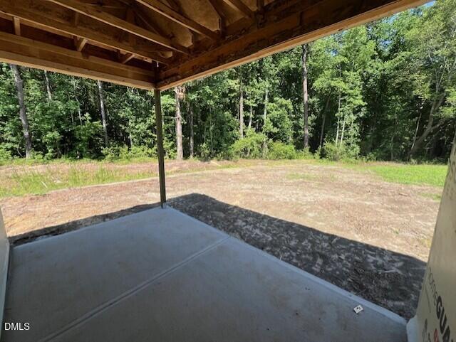 Concrete patio under construction overlooking wooded backyard in Wellers Knoll, Lillington, NC by Davidson Homes.