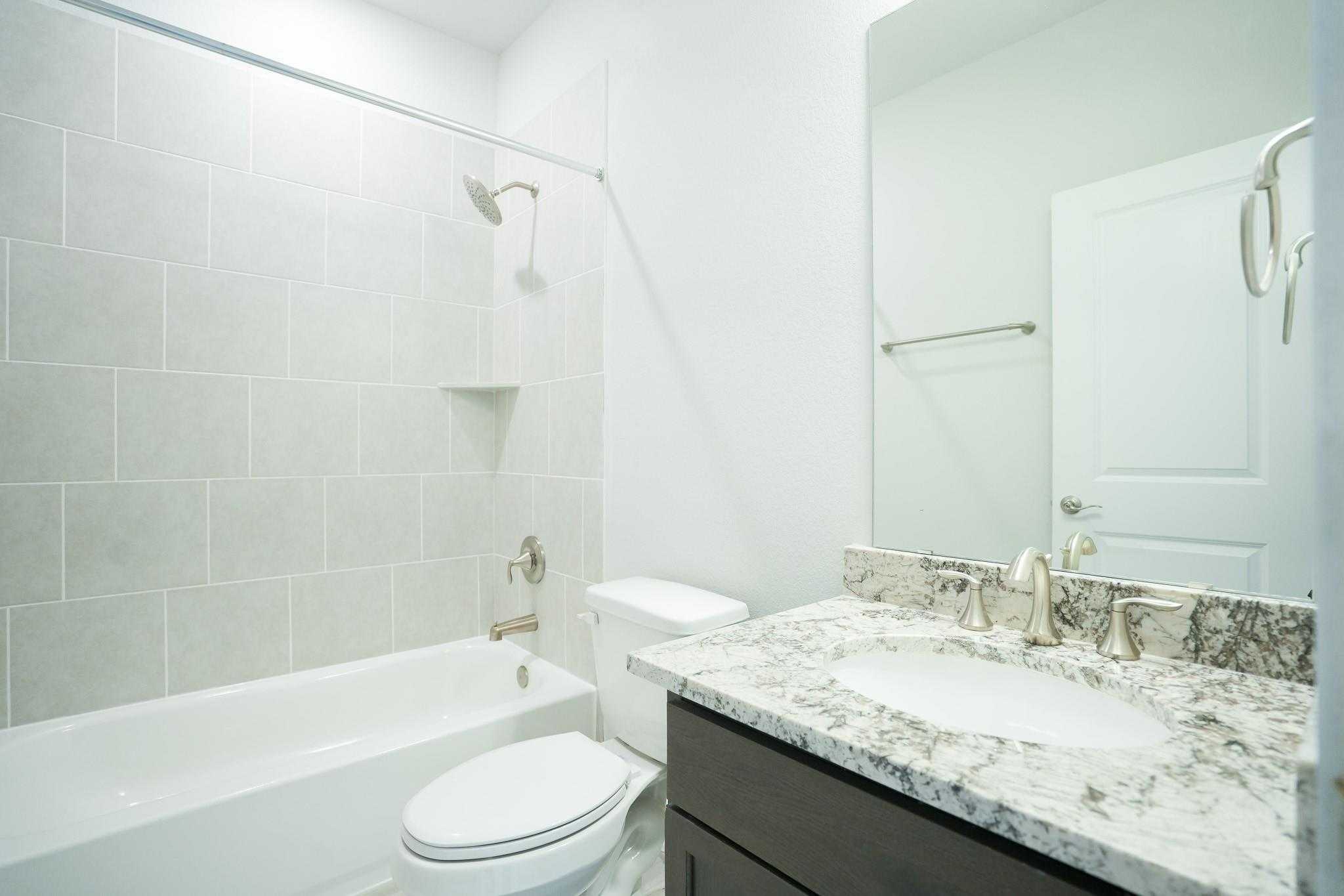 Modern bathroom with white subway tile shower, soaking tub, quartz vanity in Davidson Homes The Edward C, Lago Mar, Texas City