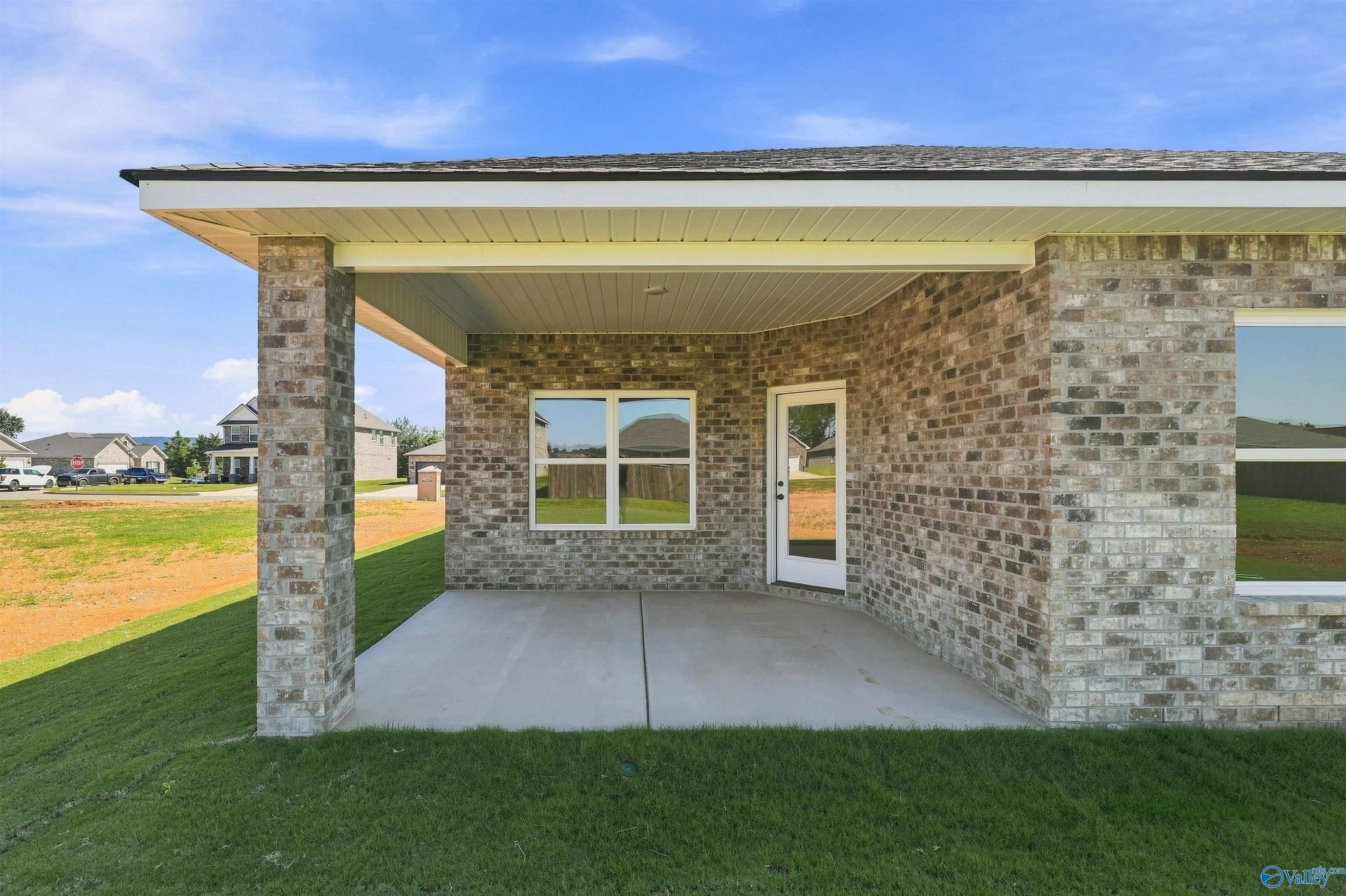 Covered brick patio with glass door and windows on Davidson Homes' The Everett B in Ivy Hills, Toney, Alabama