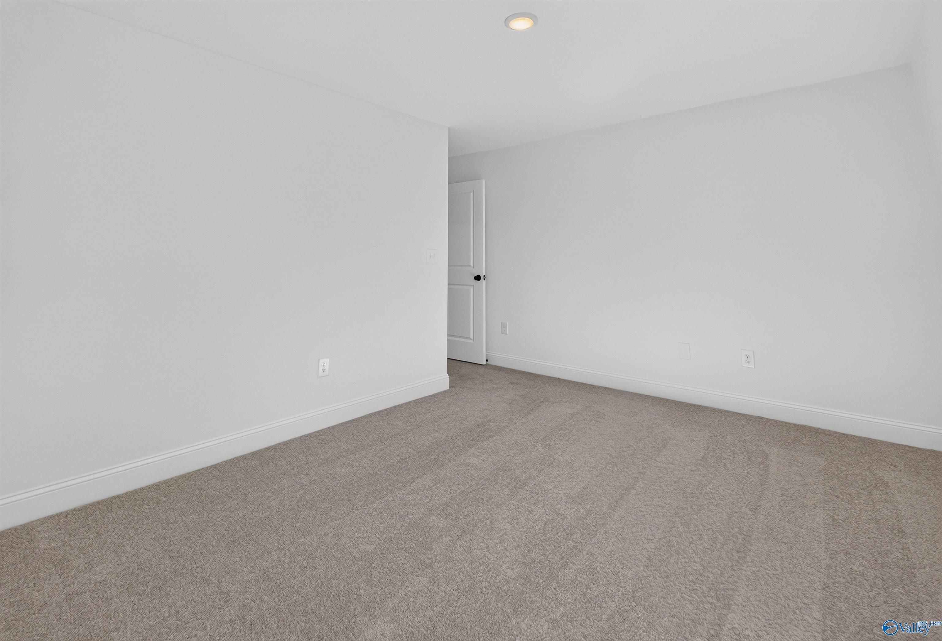 Spacious empty bedroom with neutral carpet and white walls in Davidson Homes The Ashport L floor plan, Berry Cove, New Market, Alabama