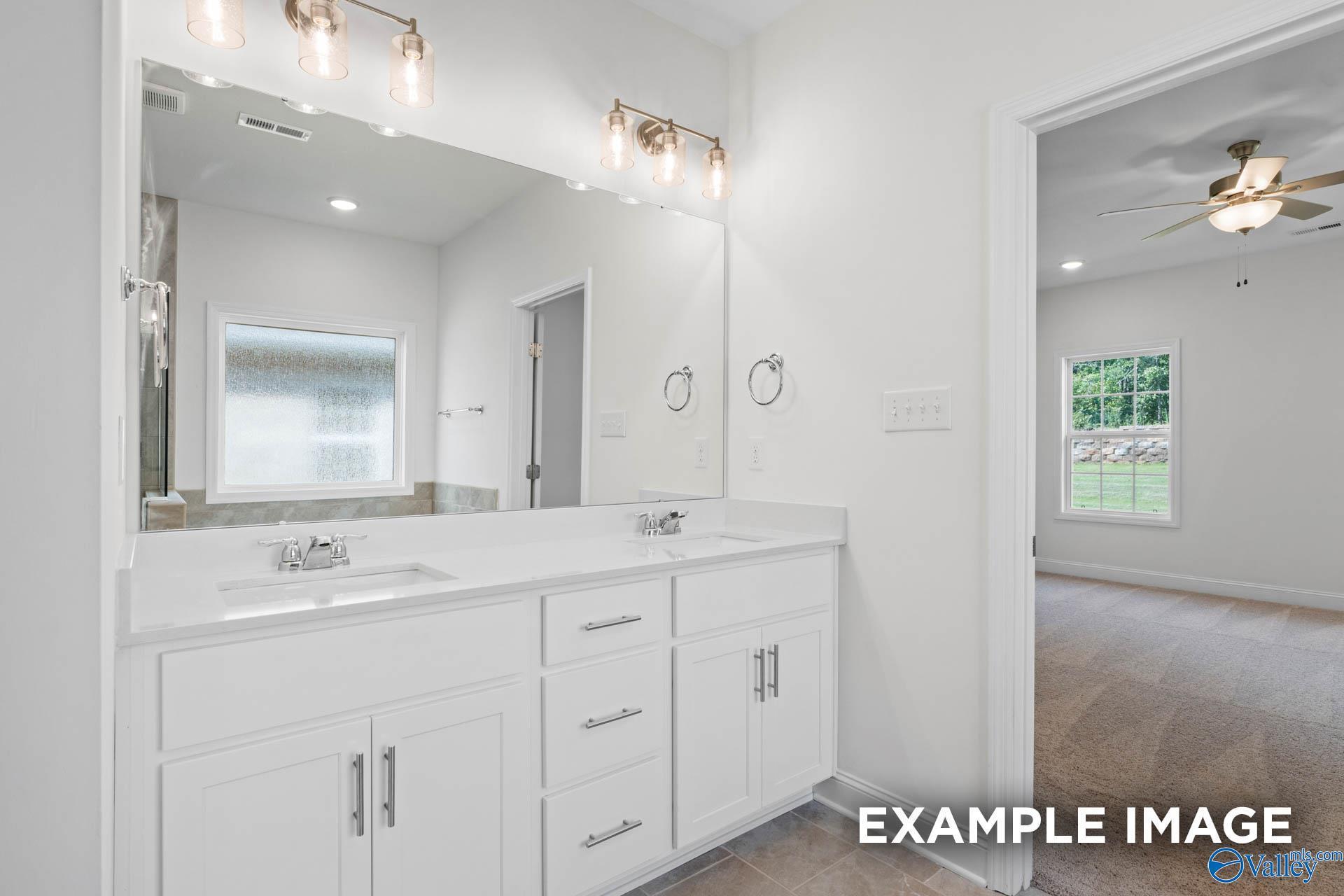 Modern master bathroom featuring double white vanity, large mirror, and bronze pendant lights in Davidson Homes The Rockford C, Madison, Alabama